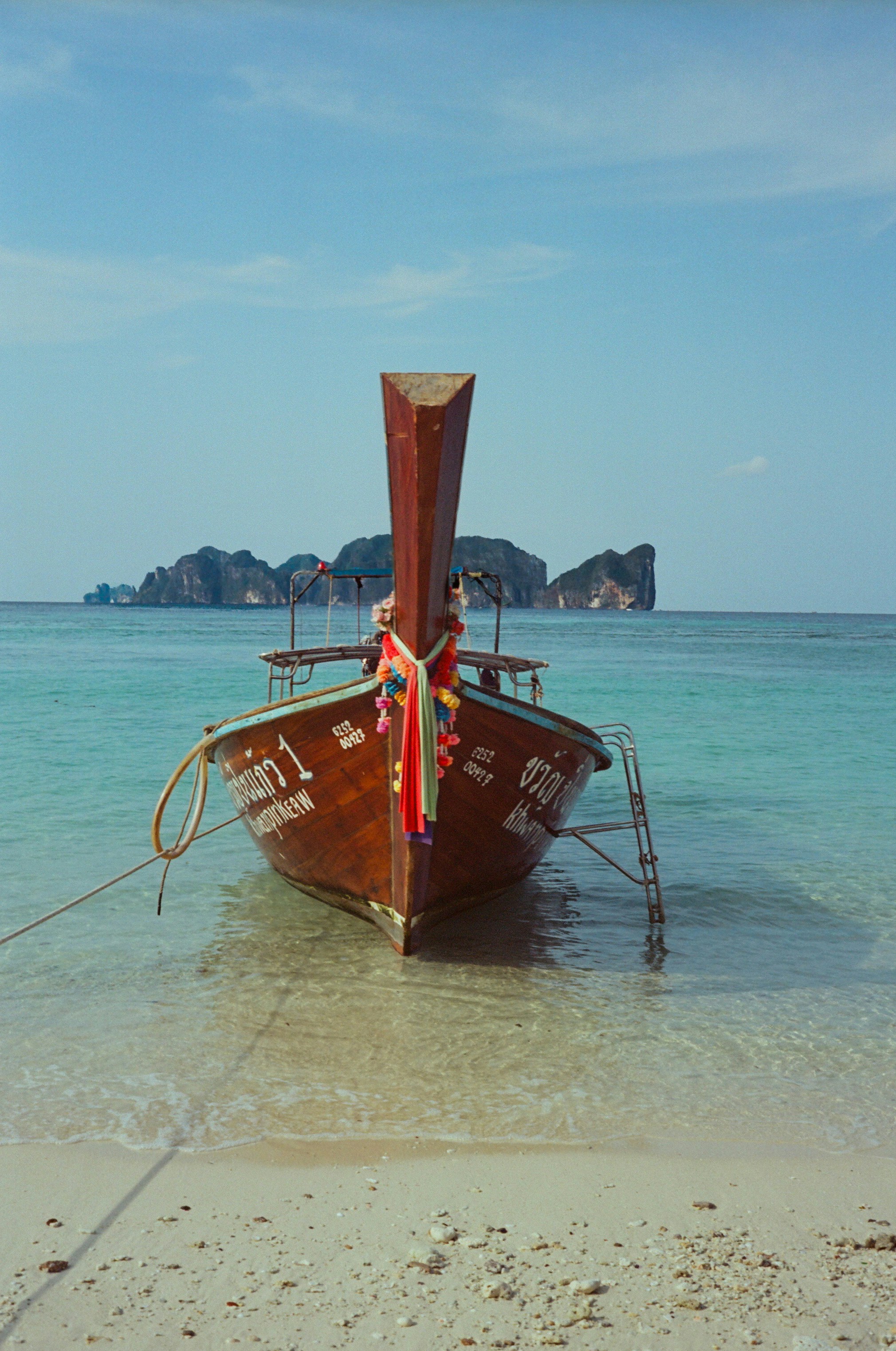 A traditional wooden boat rests on a sandy beach.