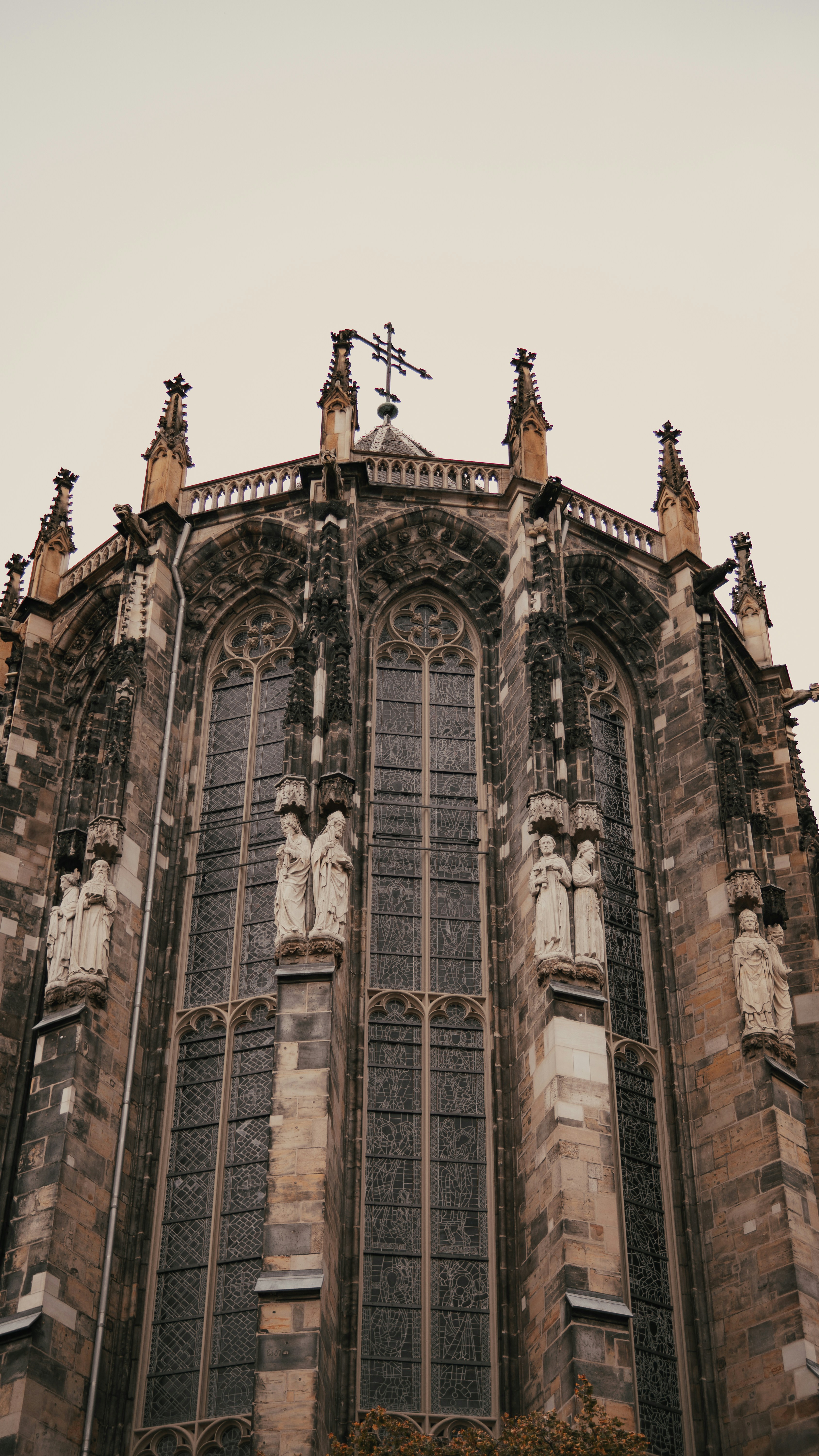 Gothic cathedral facade with tall arched windows and sculptures.