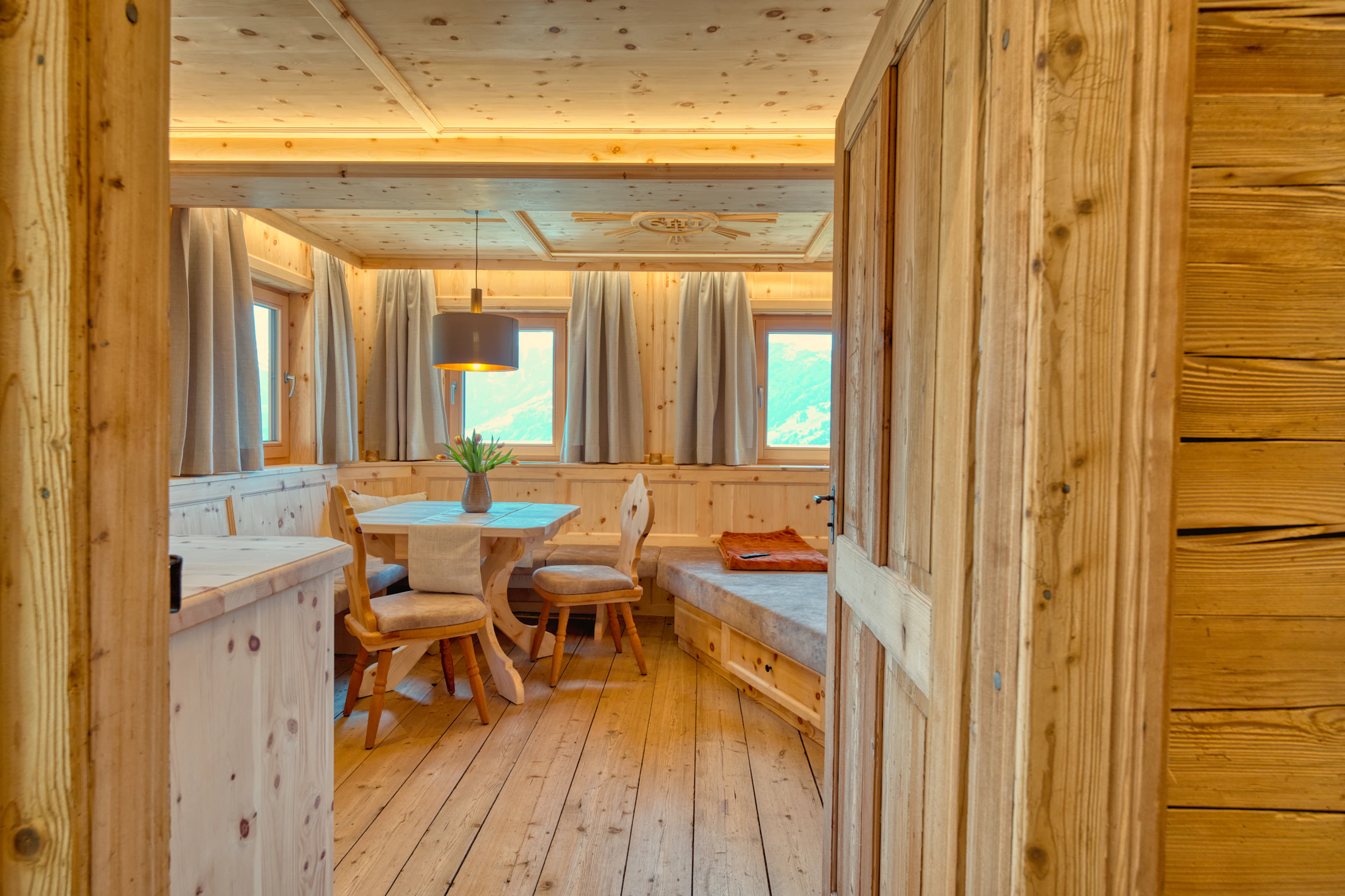 Séjour du chalet en arolle, coin repas et banquette d'angle