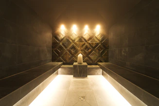 A modern steam room with a candle and ambient lighting.