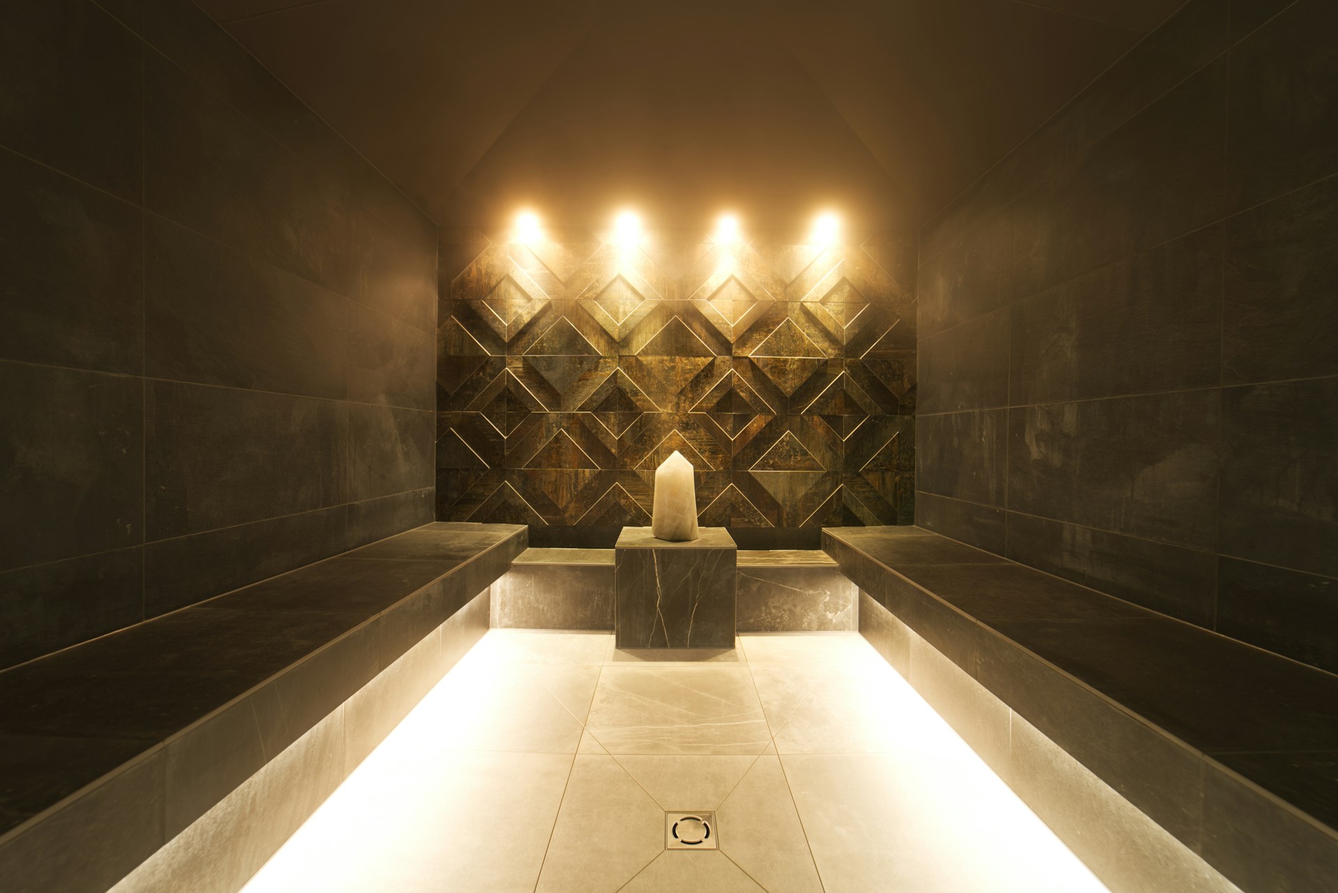 A modern steam room with a candle and ambient lighting.