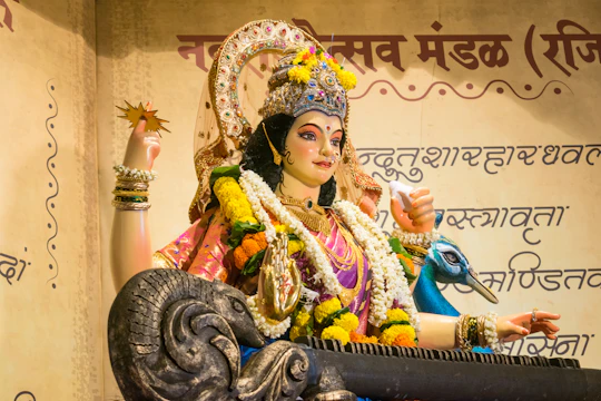 A statue of saraswati with a peacock