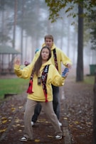 Young couple posing in yellow hoodies outdoors