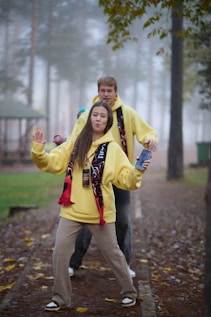 Young couple posing in yellow hoodies outdoors