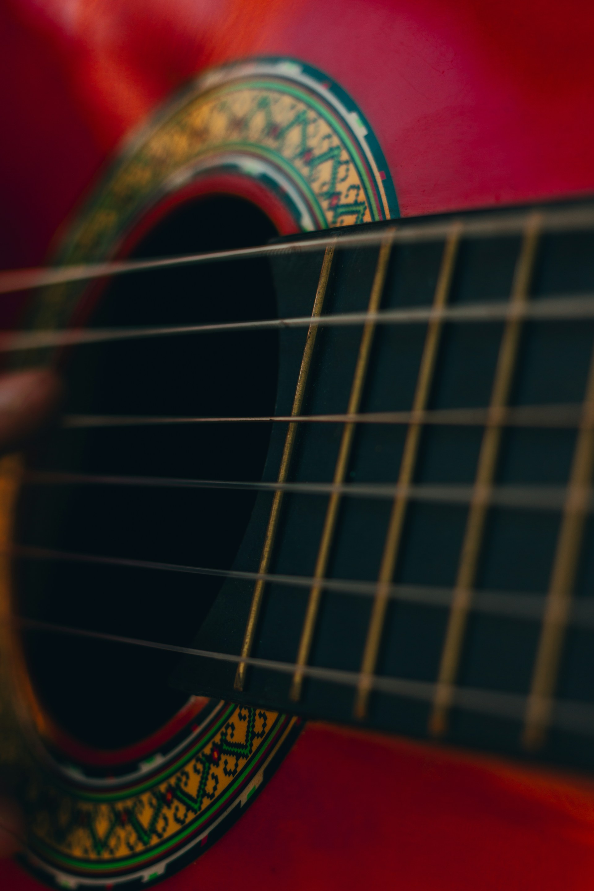 Close-up of a red acoustic guitar strings.