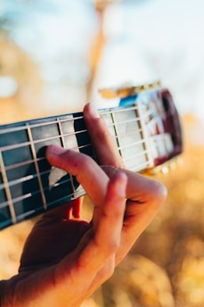 Close up of a hand playing guitar outdoors