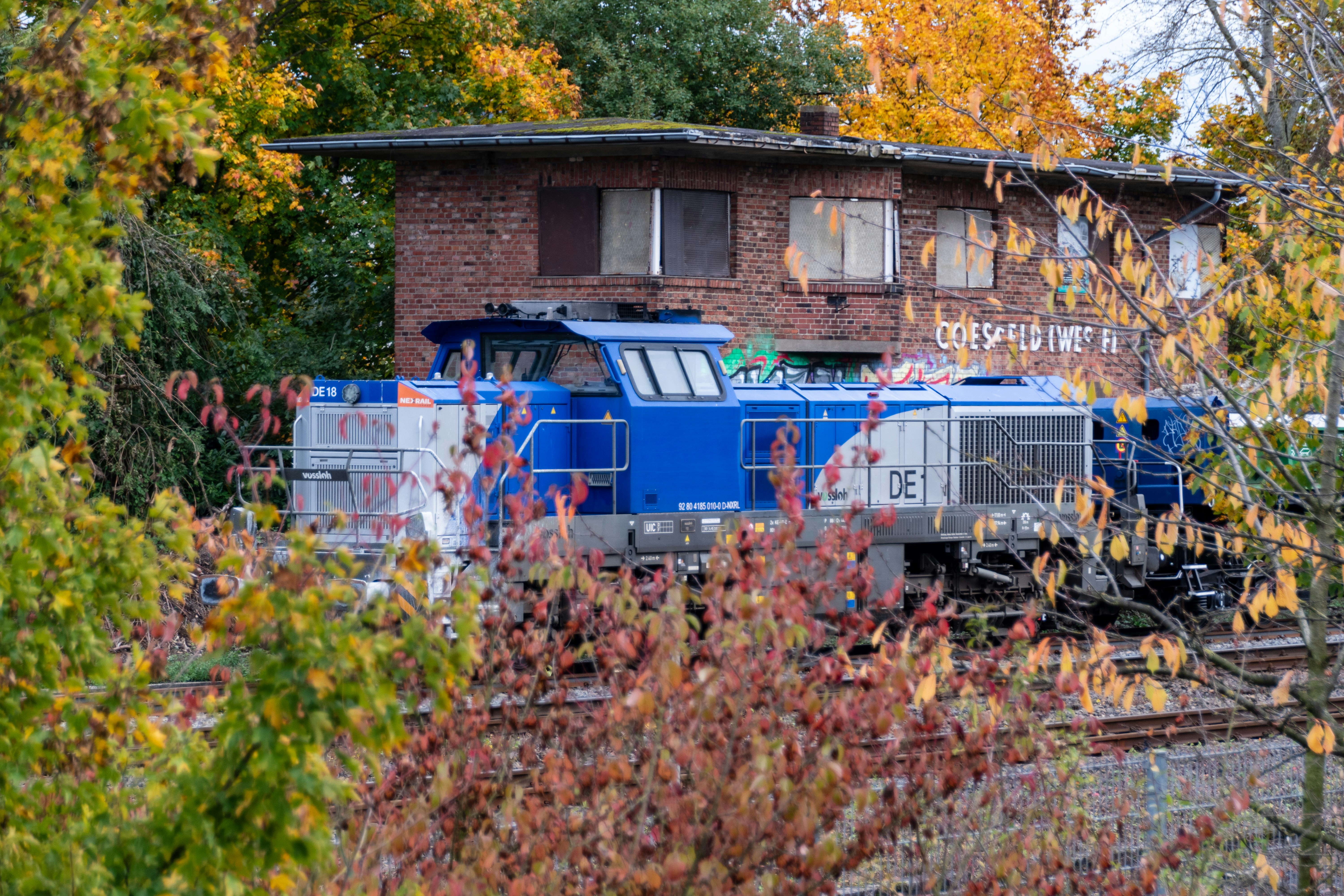 Blue train engine parked near brick building photo – Free Travel Image ...
