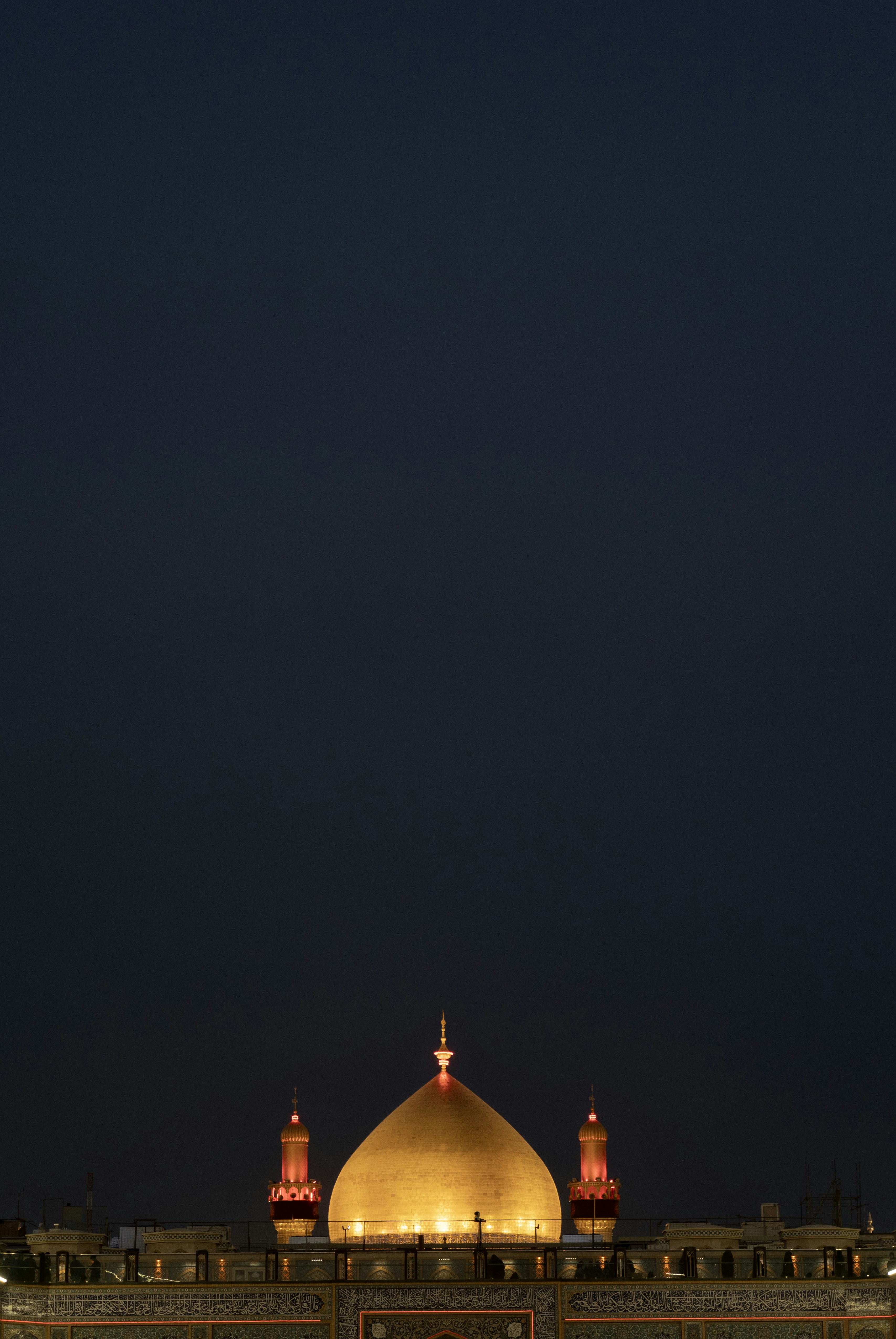 Golden dome and minarets illuminated at night