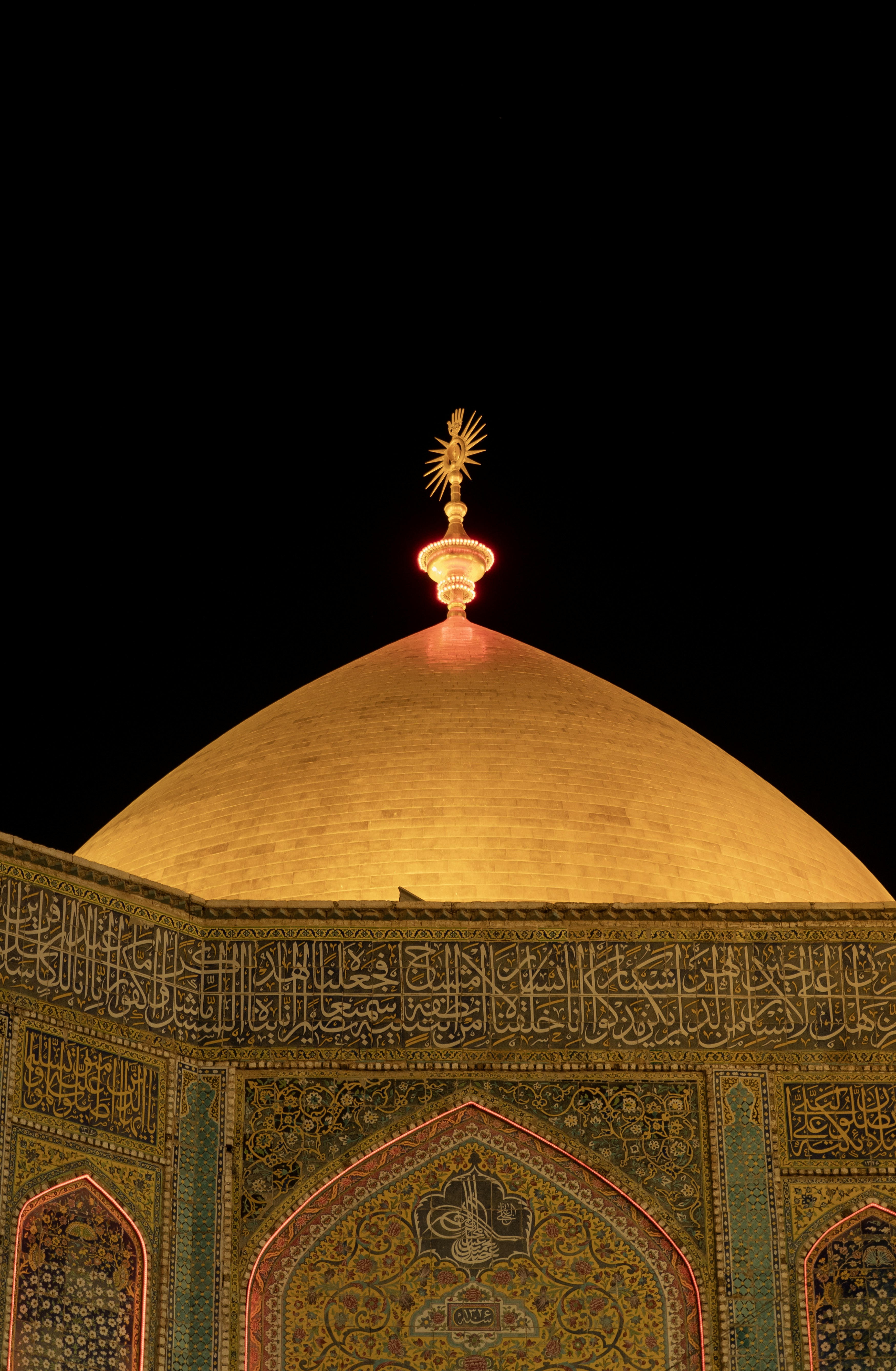 Golden dome of a mosque illuminated at night