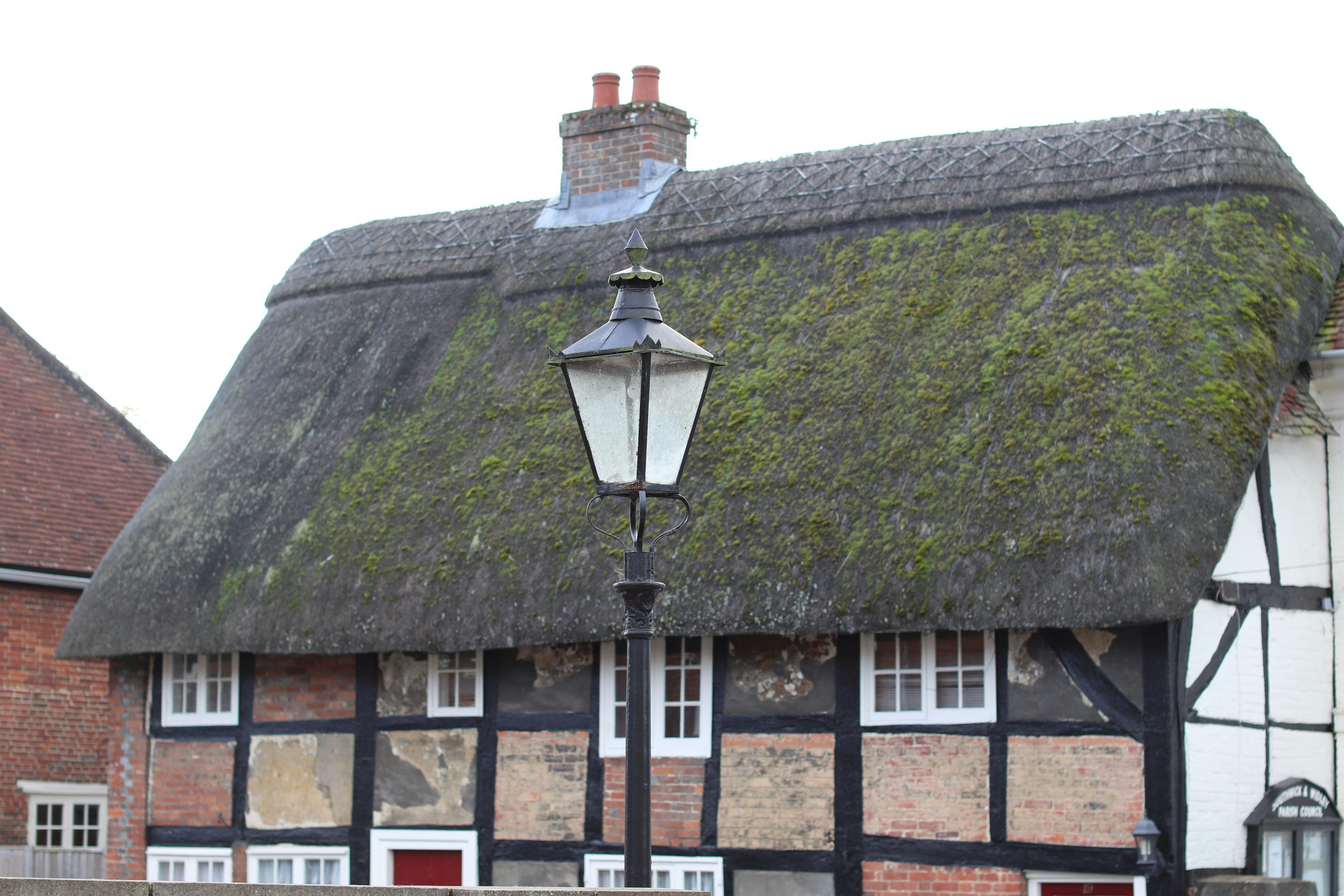 Thatched roof cottage with lamppost