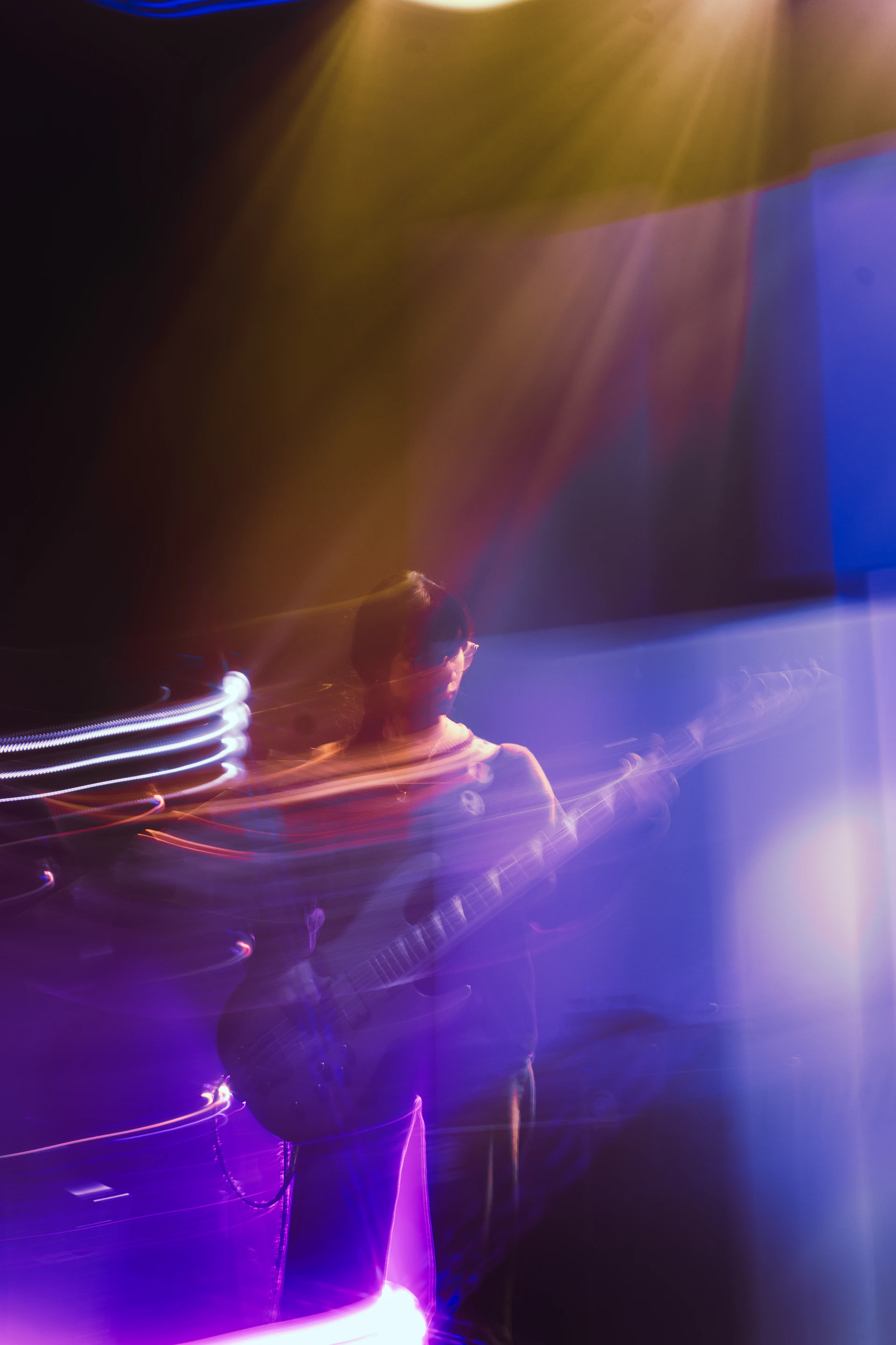 Musician playing guitar with colorful stage lights