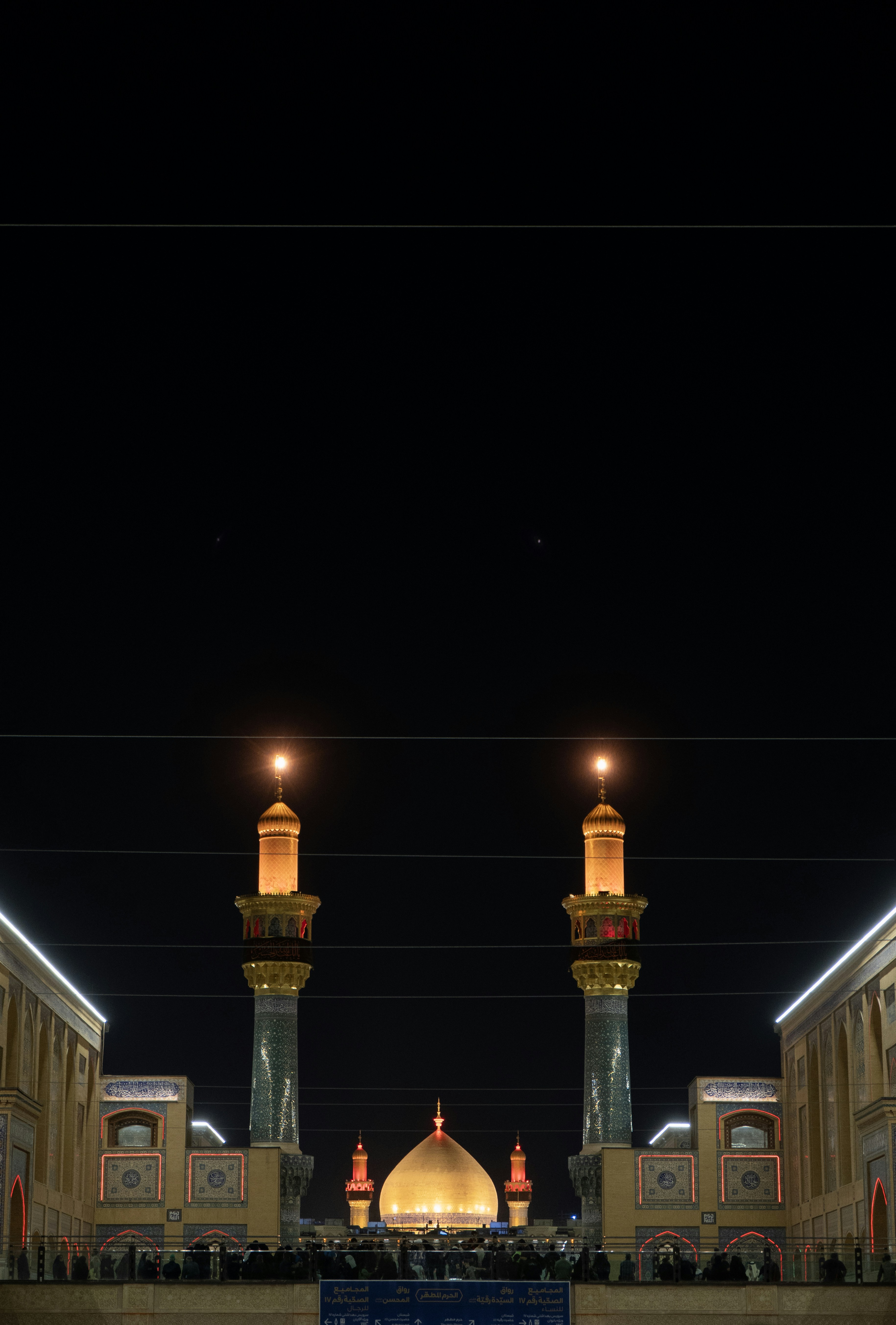 Mezquita iluminada con cúpula dorada y minaretes por la noche