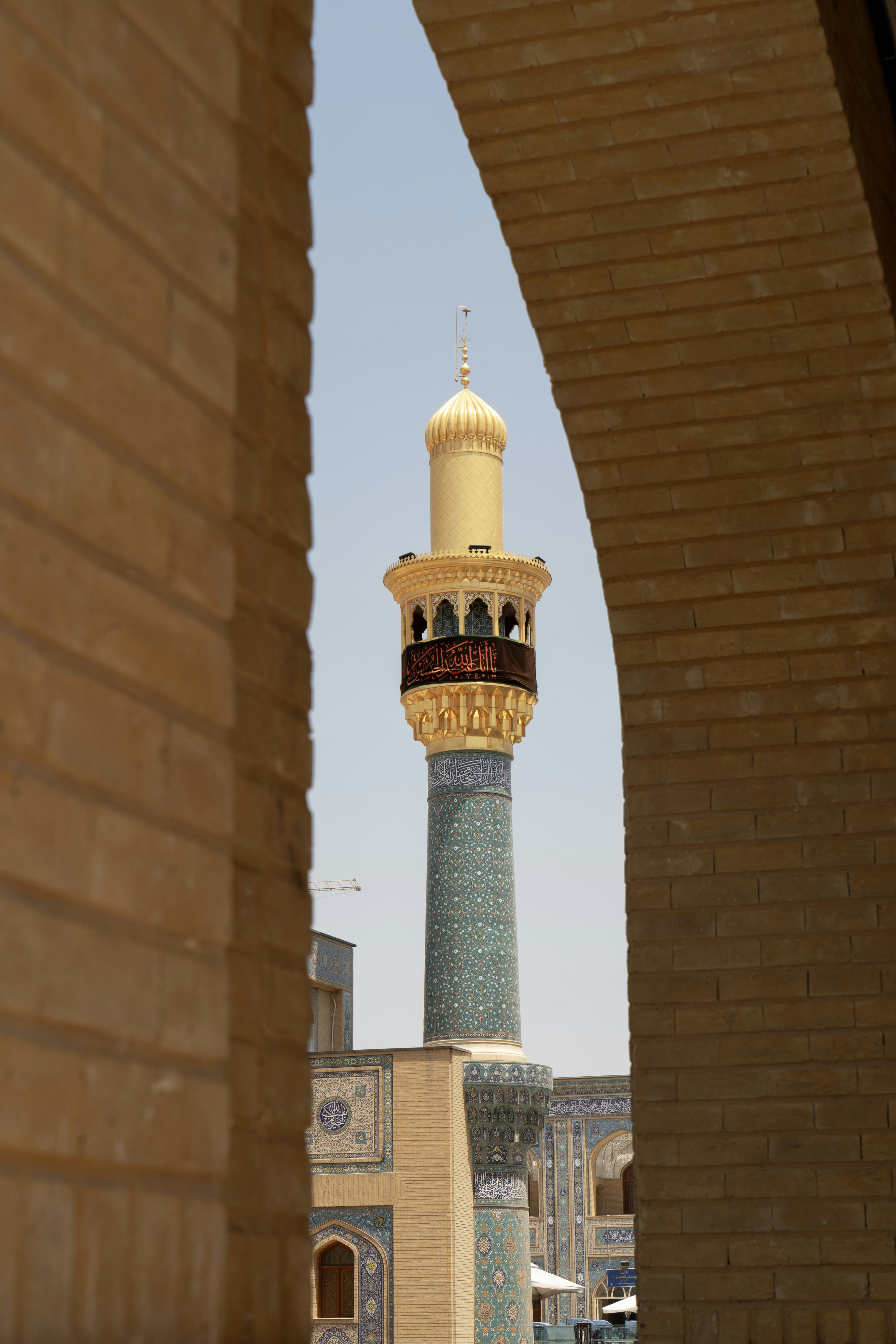 Grand minaret d’une mosquée avec un carrelage bleu complexe.