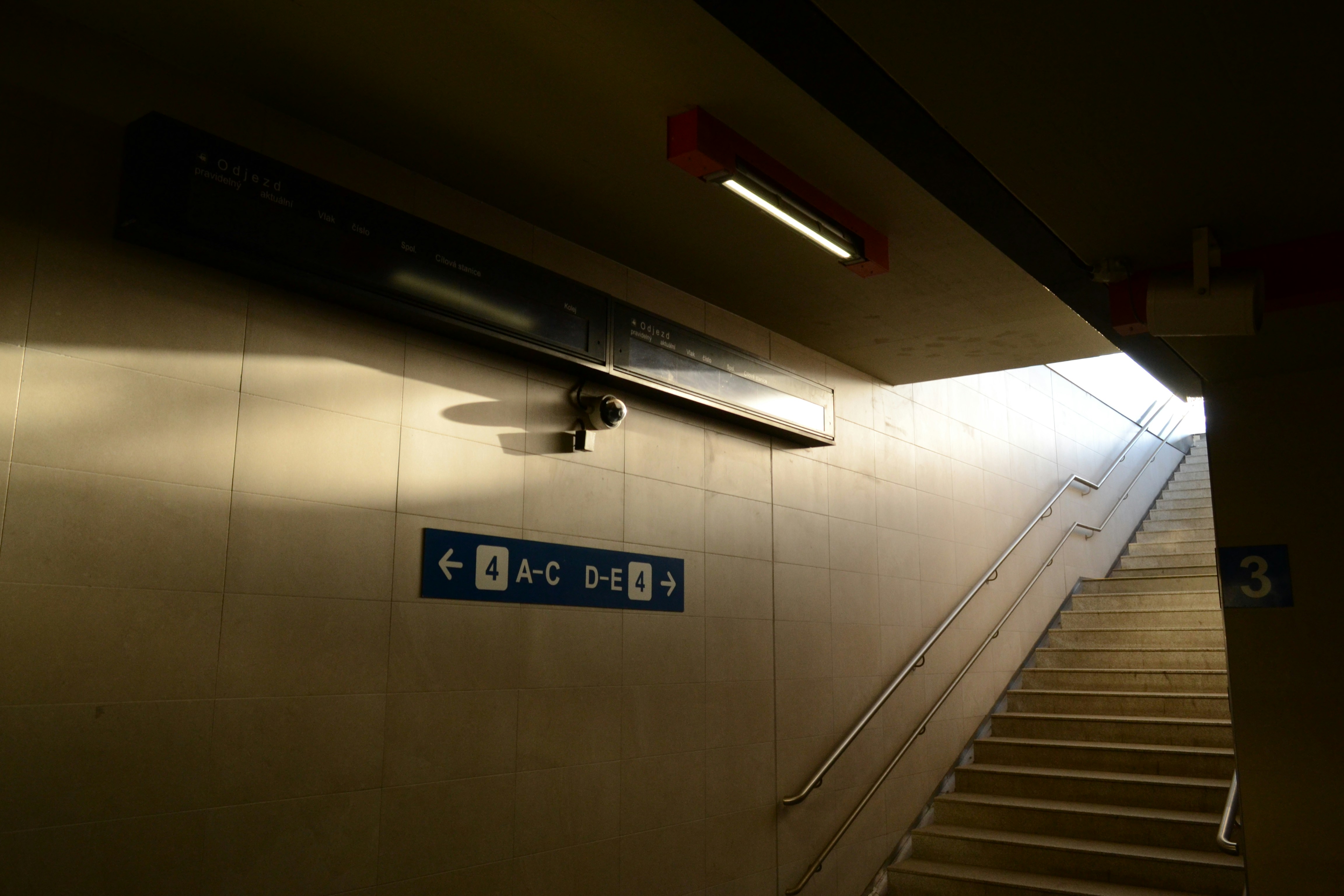 Stairs leading up towards bright light in subway station.