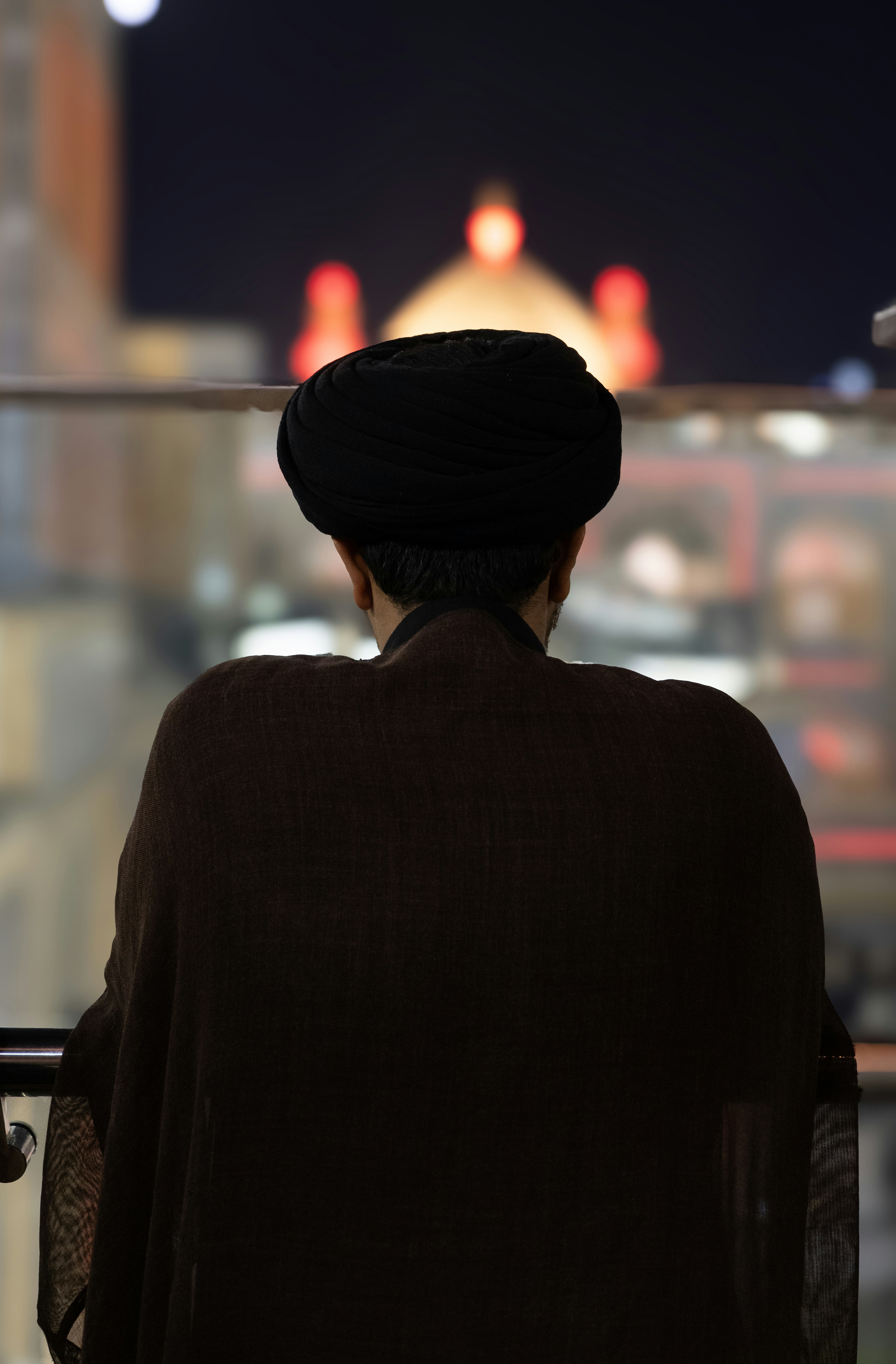 Hombre con turbante mirando un edificio iluminado