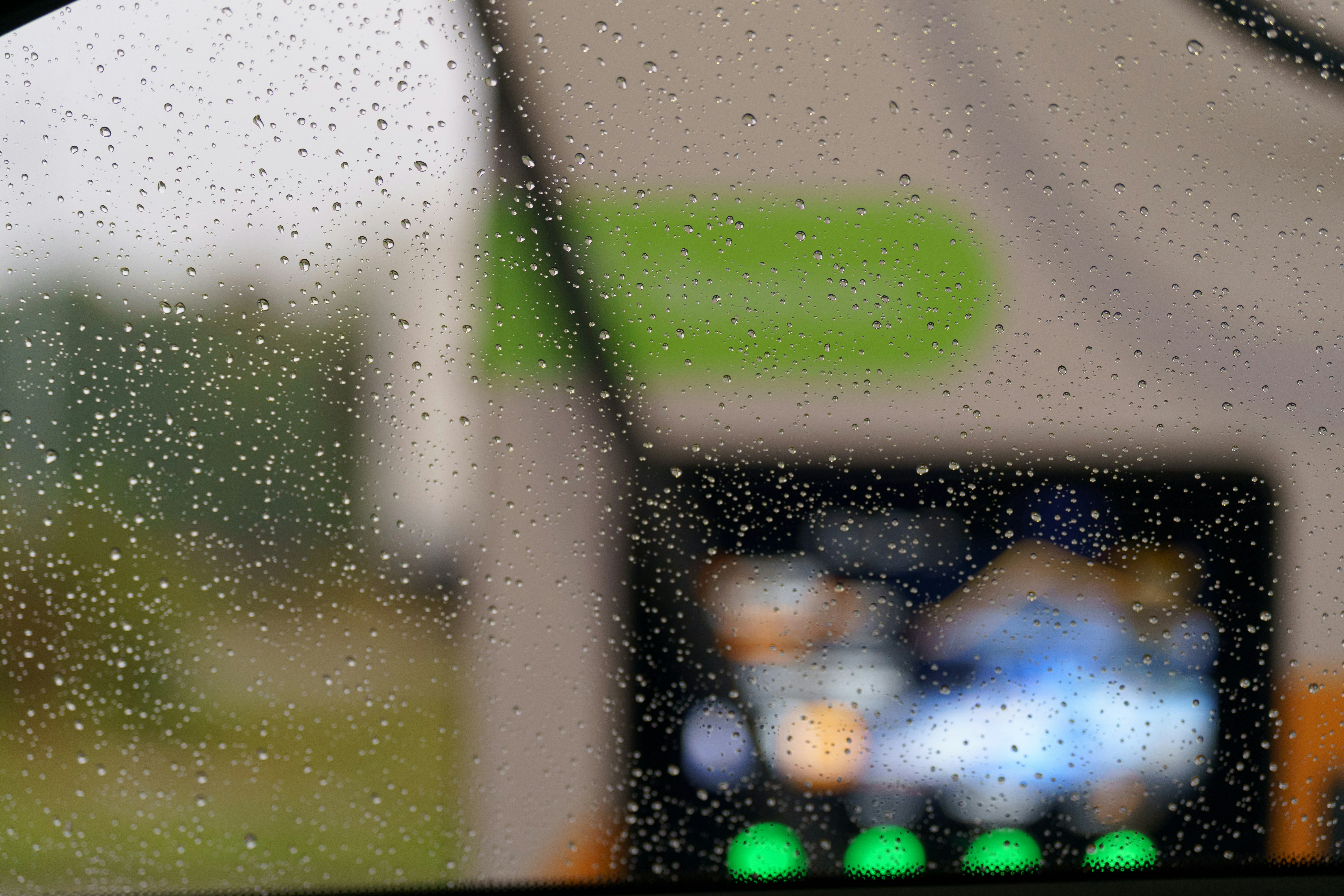 Raindrops on a car windshield with blurred background