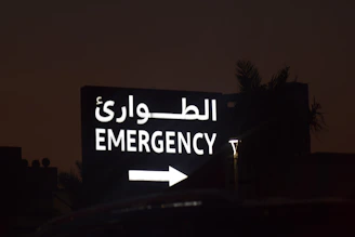 Emergency sign with arabic text and arrow