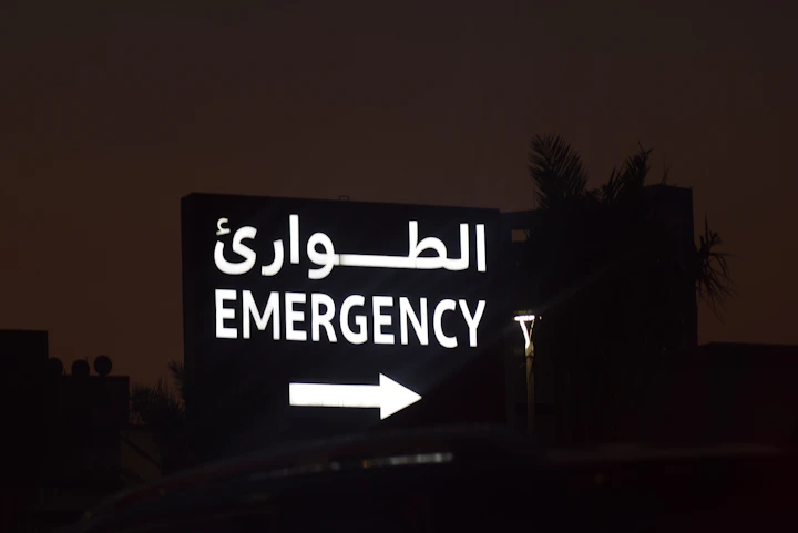 Emergency sign with arabic text and arrow