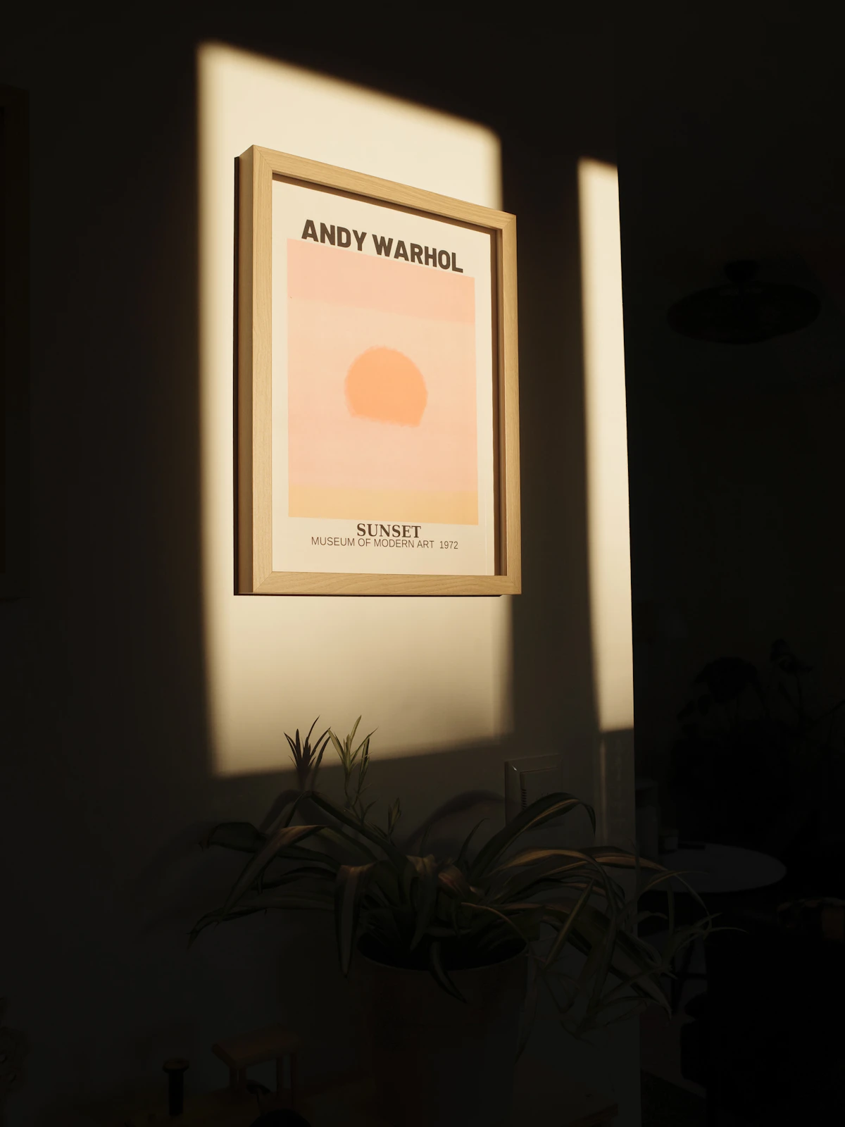 Framed typographic print on a wall in sunlight