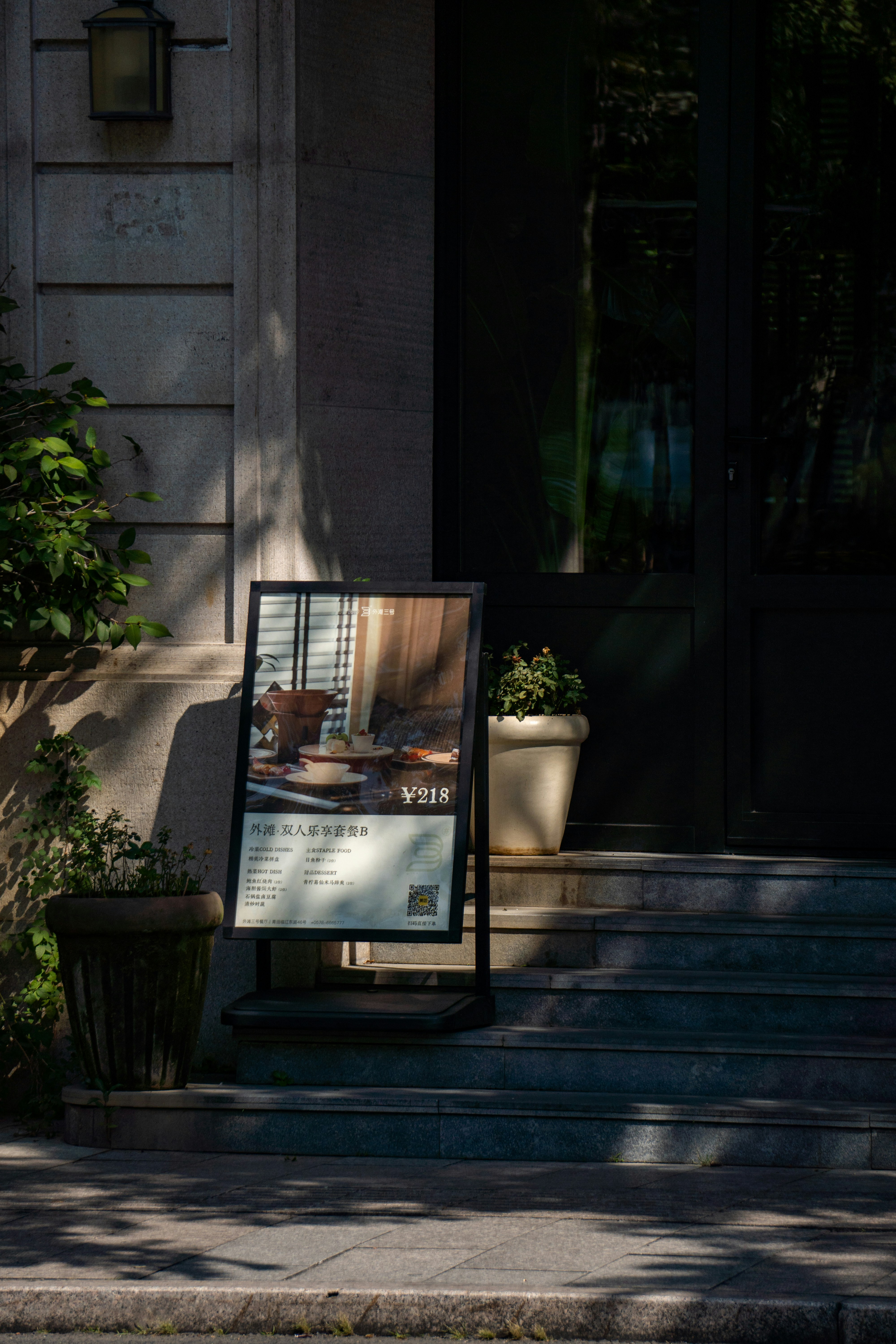 A sign stands on steps outside a building.