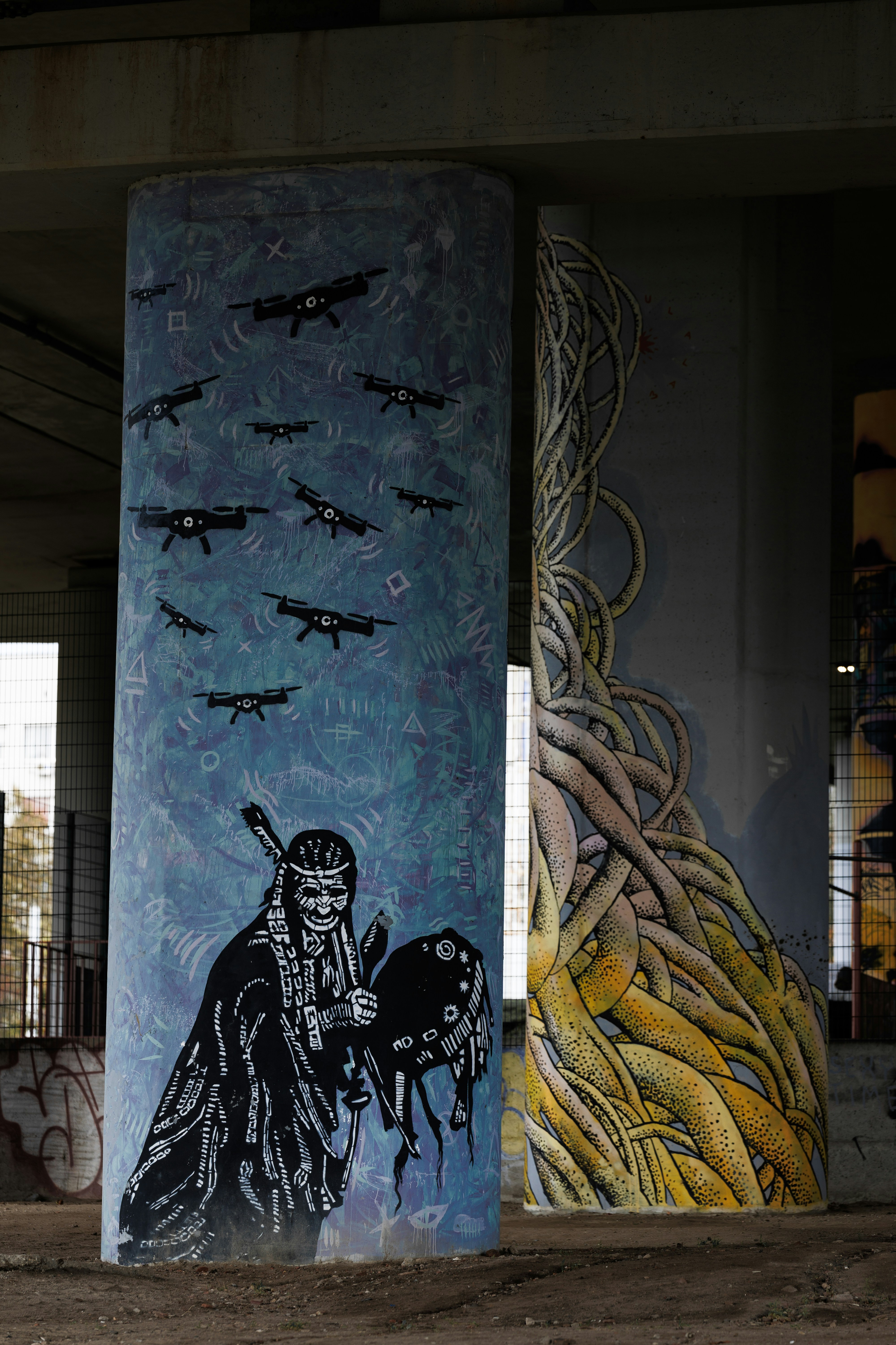 Graffiti art on concrete pillars depicts native american and roots.