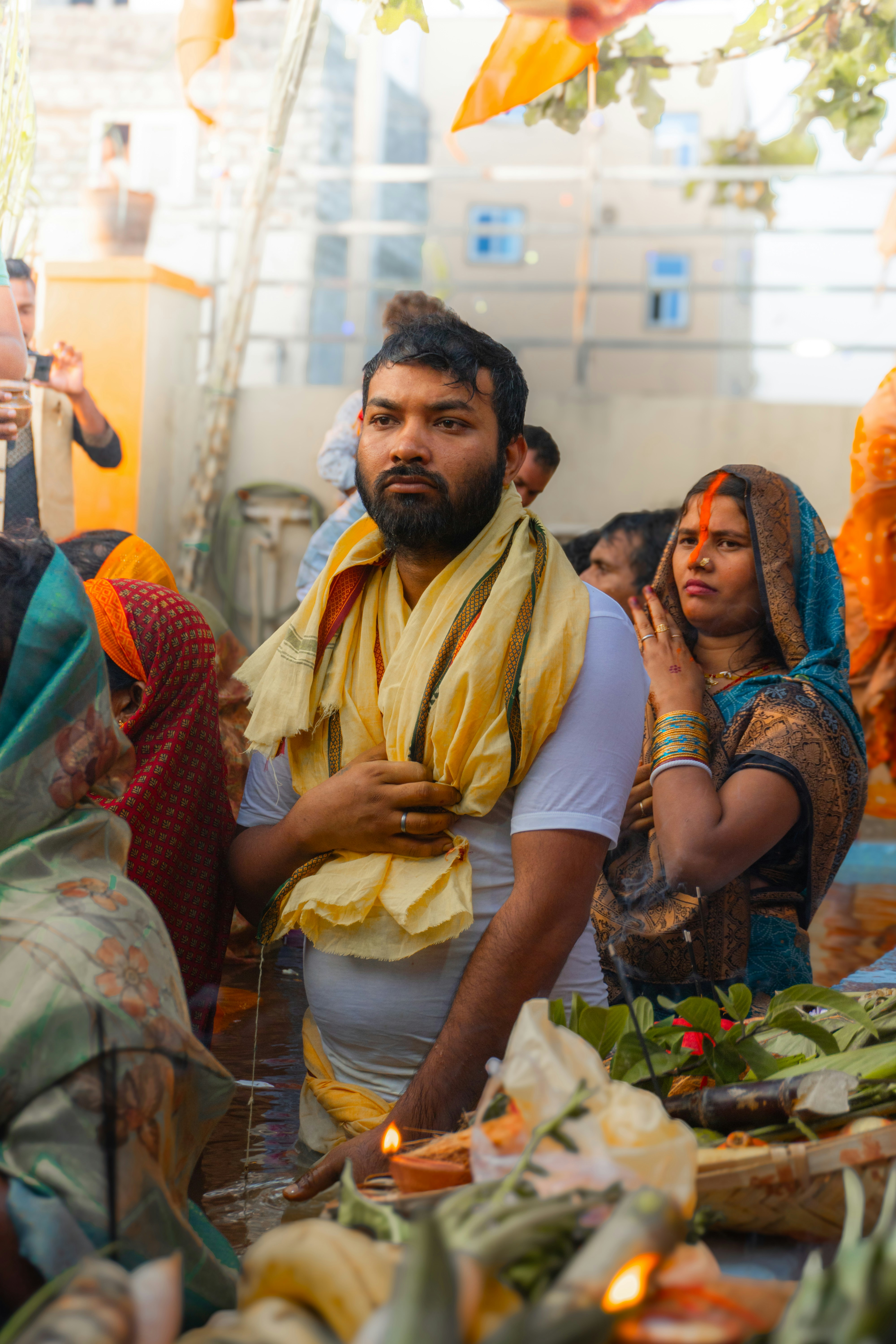 A man wearing a yellow scarf at a religious gathering.