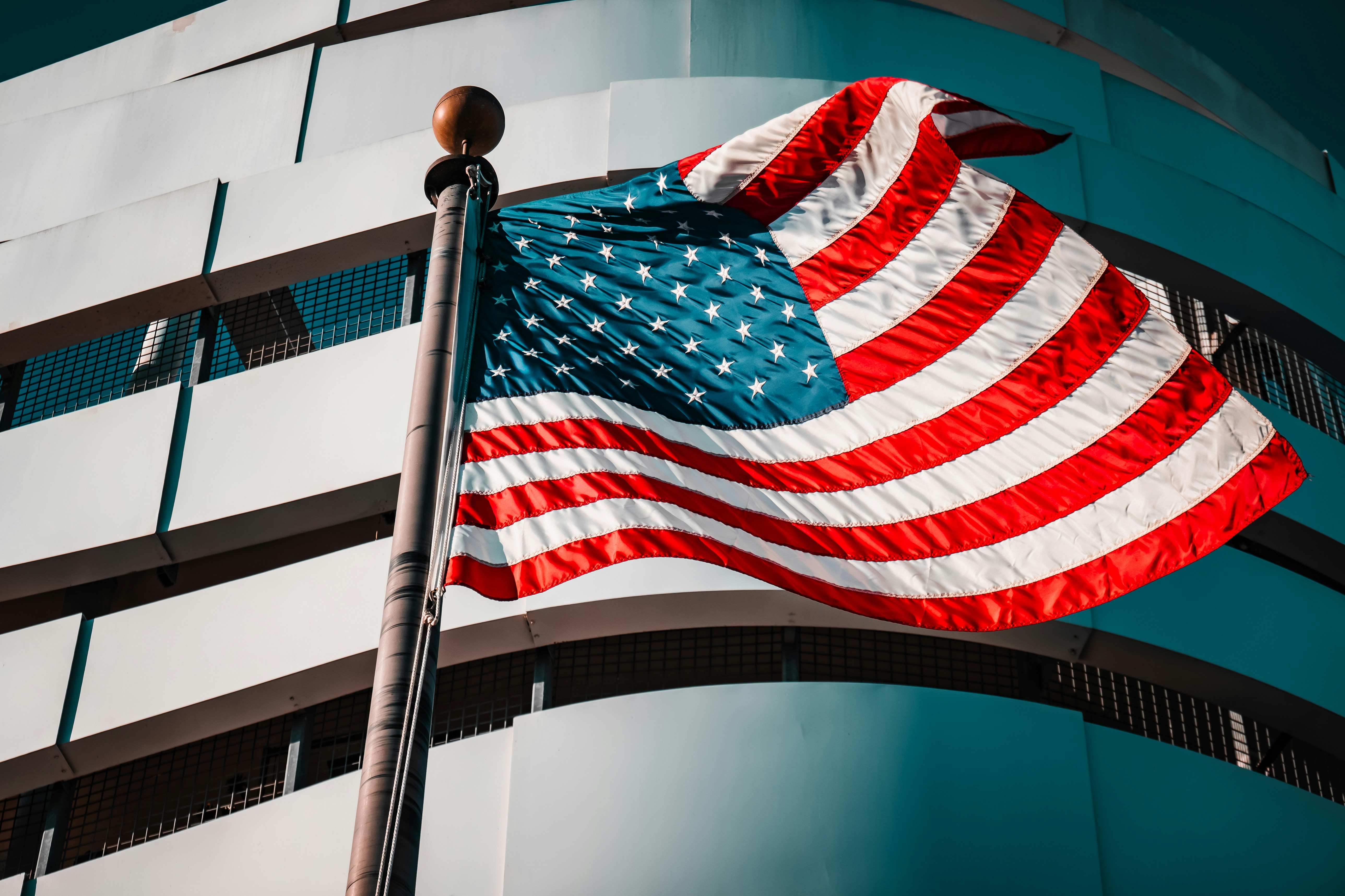 American flag waving in front of a modern building