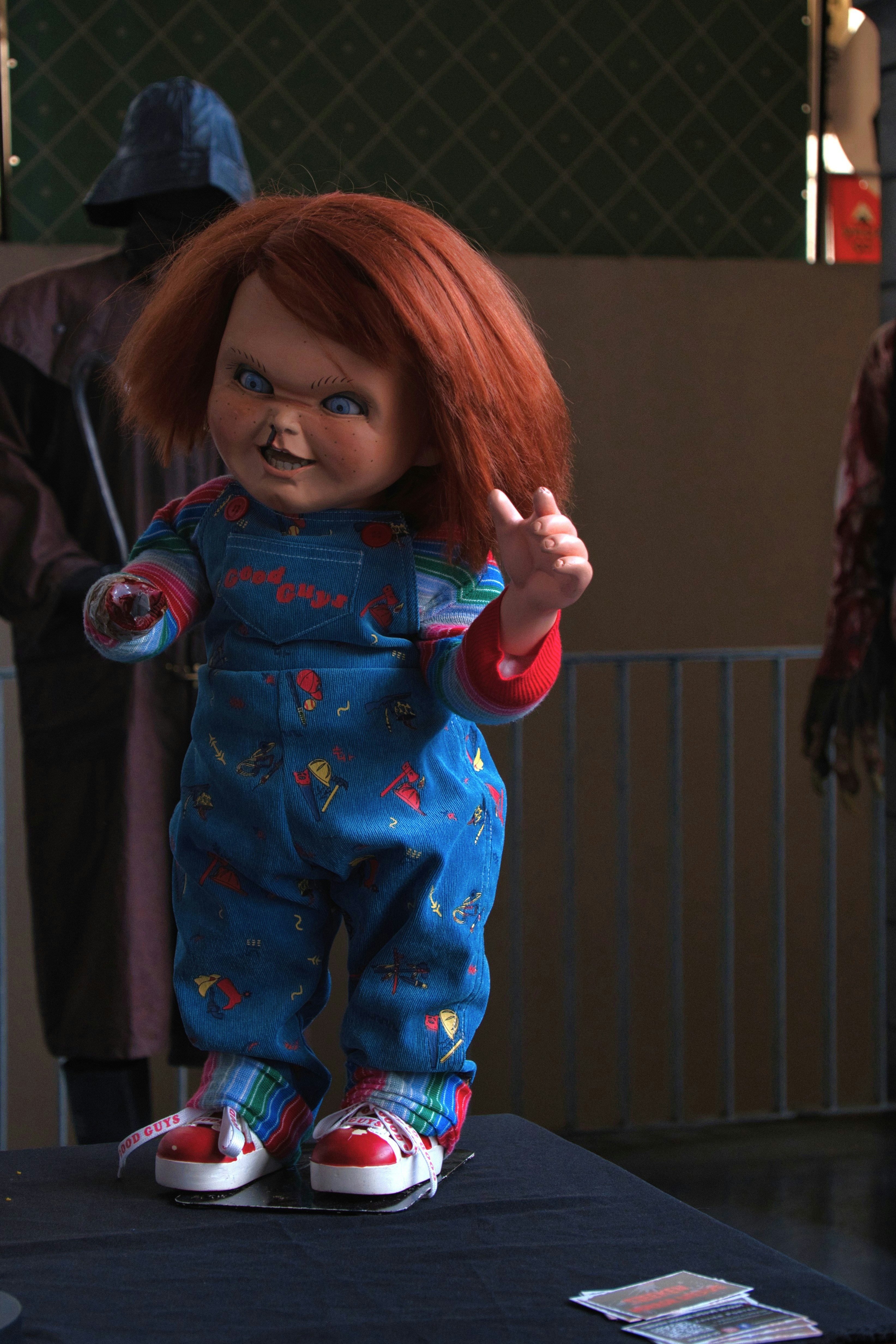 A creepy doll with red hair and overalls.