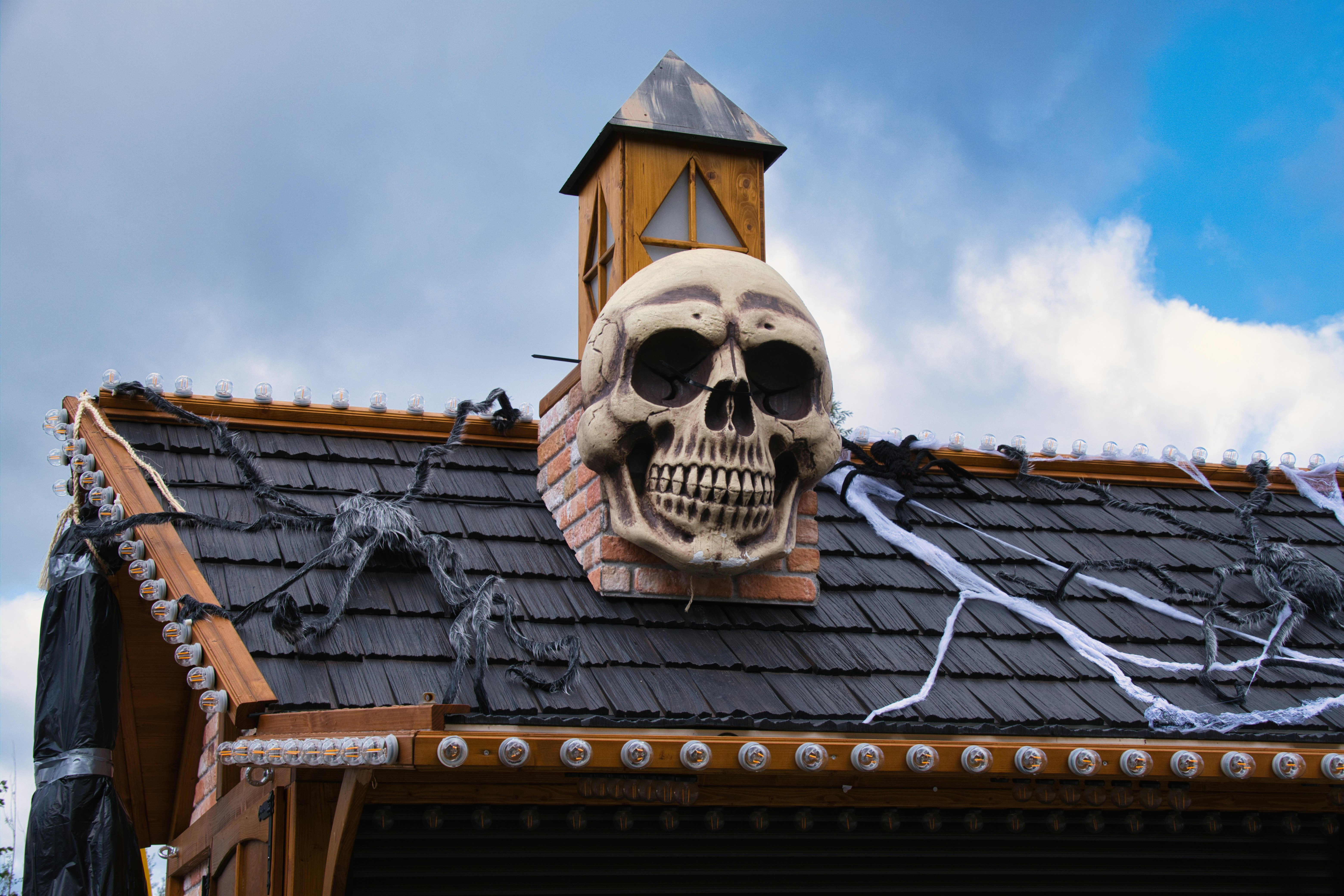 Totenkopf-Deko auf einem gruseligen Spukhausdach