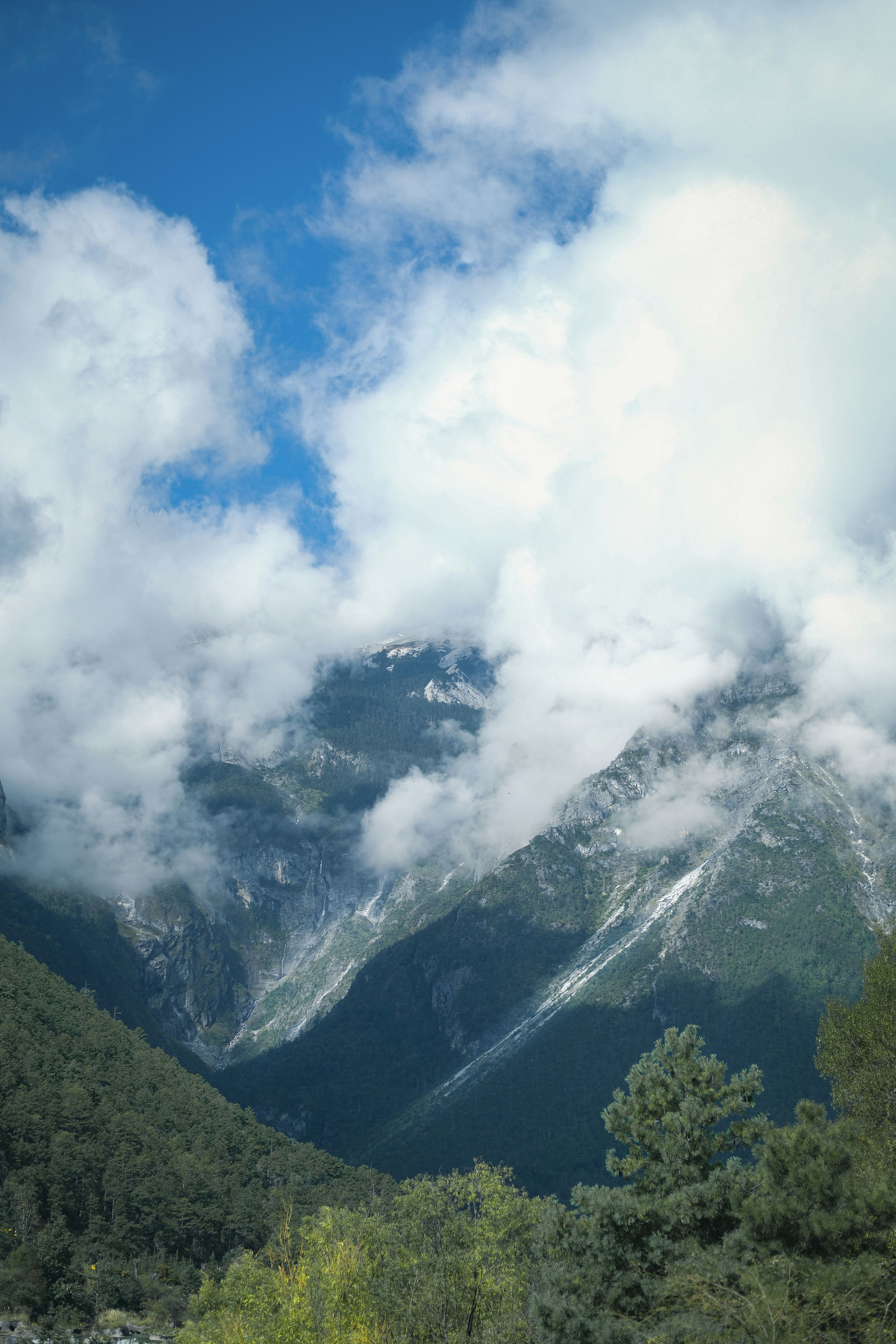 Misty mountains with green trees and blue sky