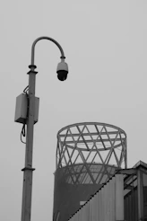 Security camera on a pole with building in background