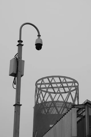Security camera on a pole with building in background
