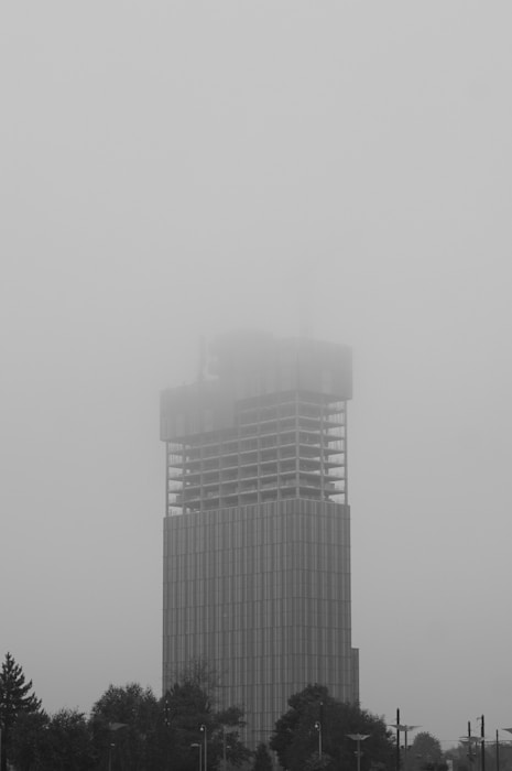 Skyscraper under construction shrouded in fog.