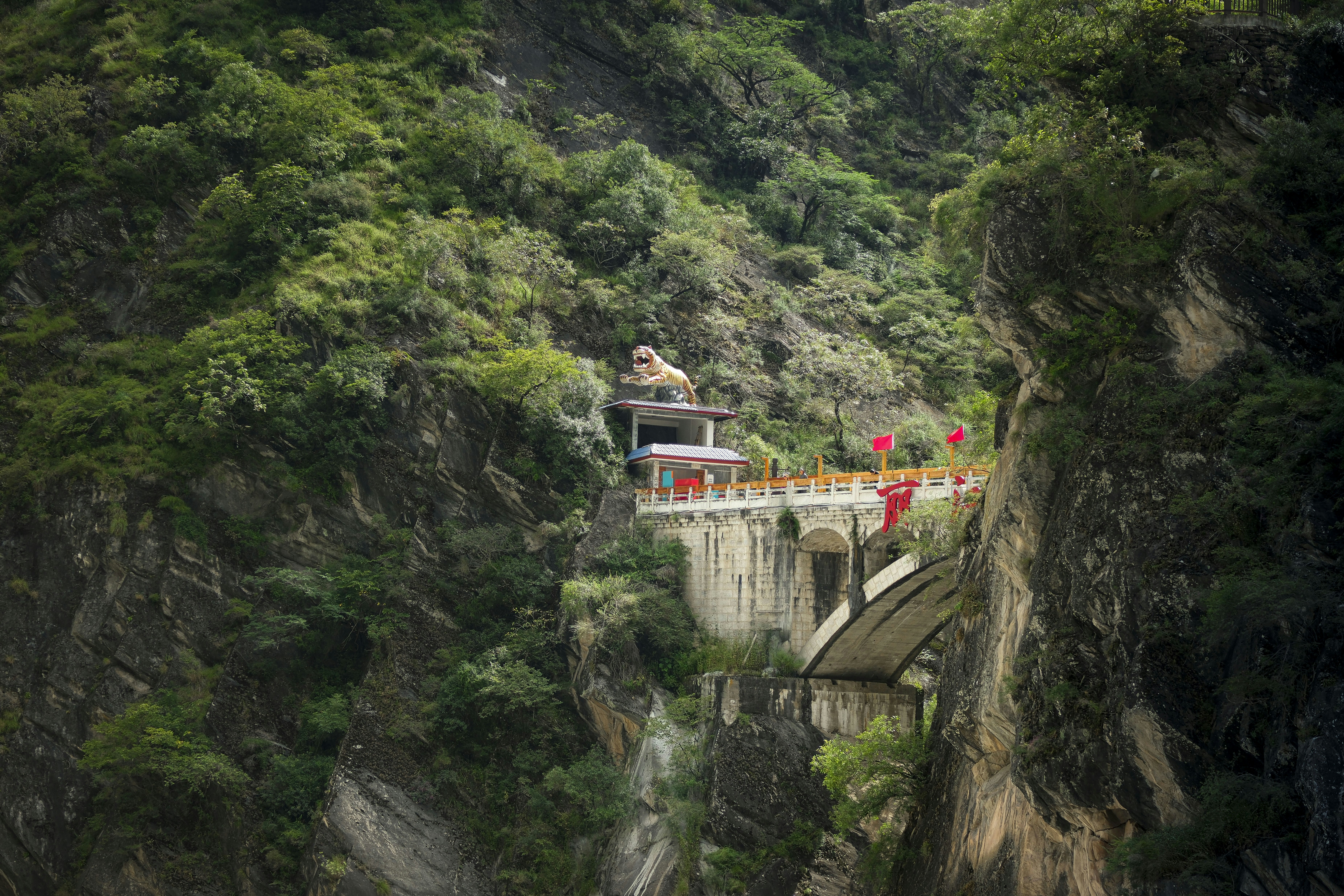 Temple nestled on a steep, green mountainside.