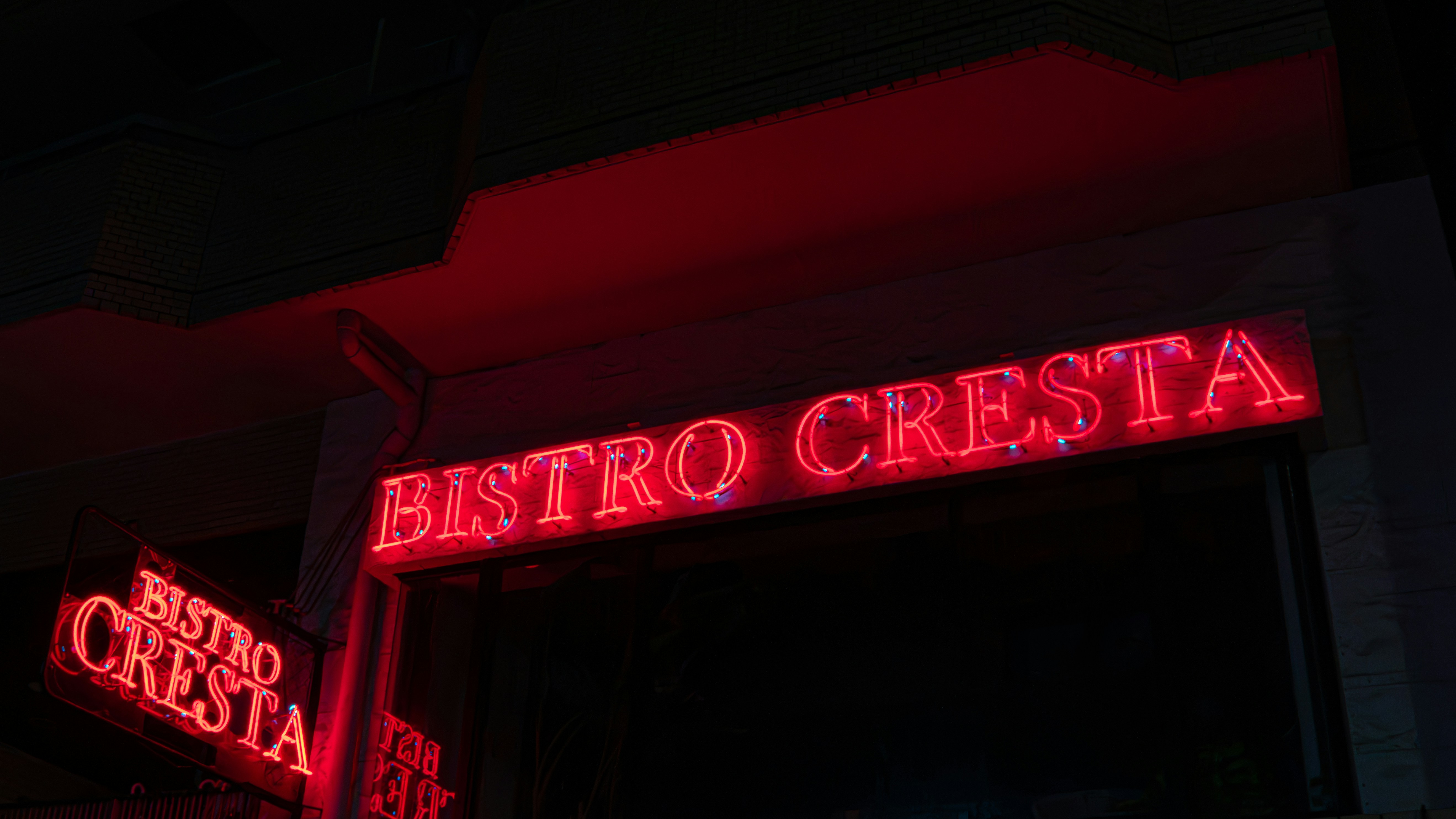 Red neon sign for bistro cresta at night