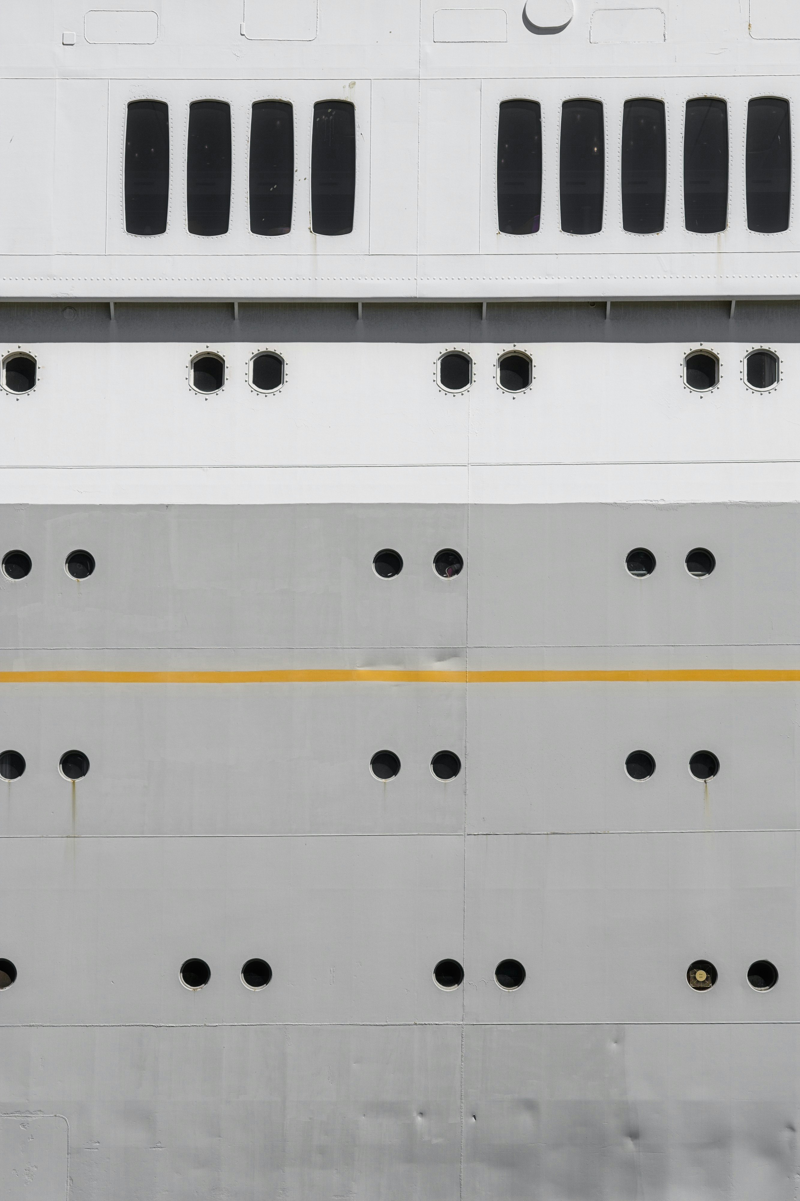 Close-up lambung kapal besar dengan jendela.