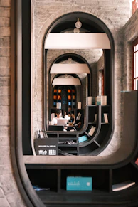 Person working in a modern library with arched doorways.