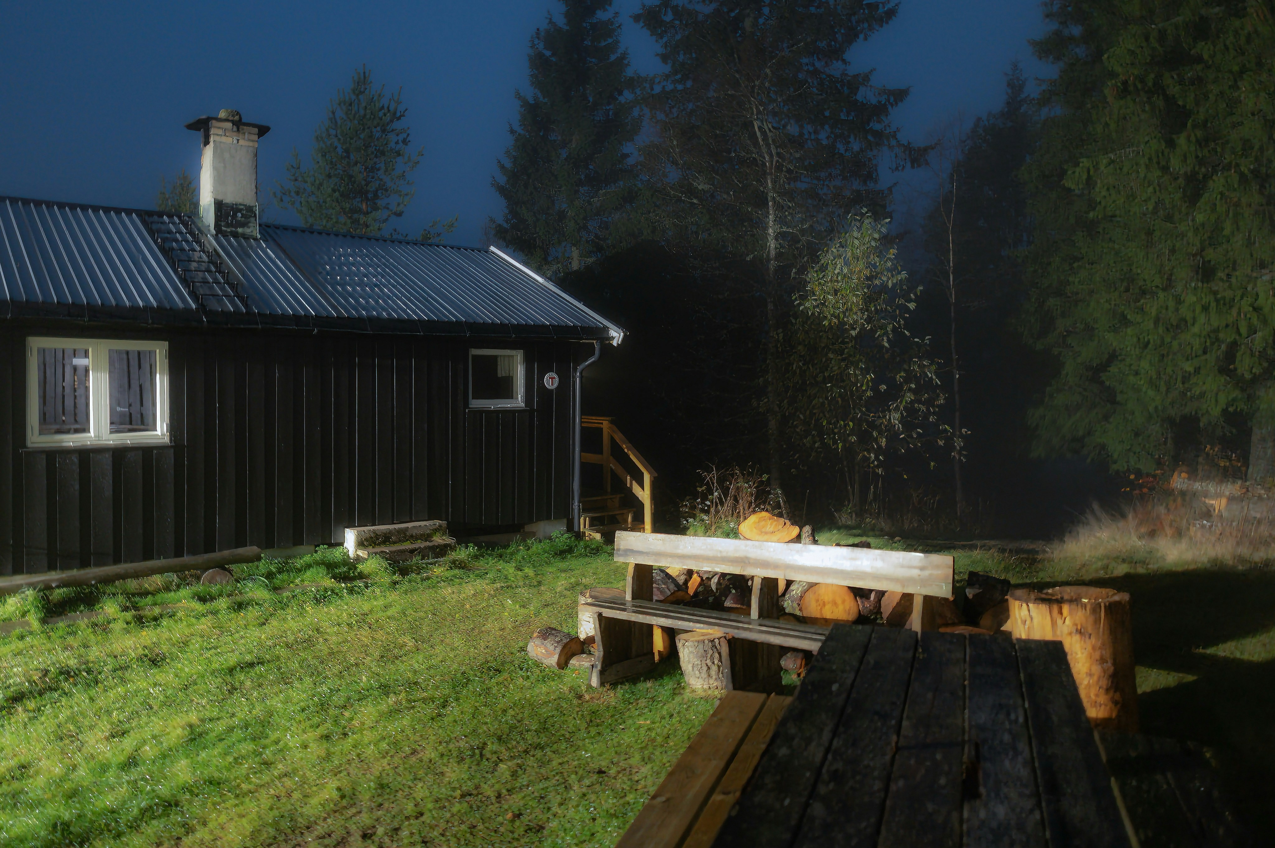 Dark wooden cabin in forest at night