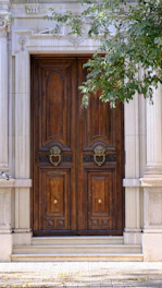 Ornate wooden double doors with lion head knockers