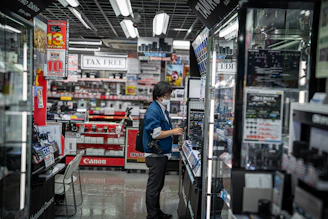 Person browsing electronics in a brightly lit store.