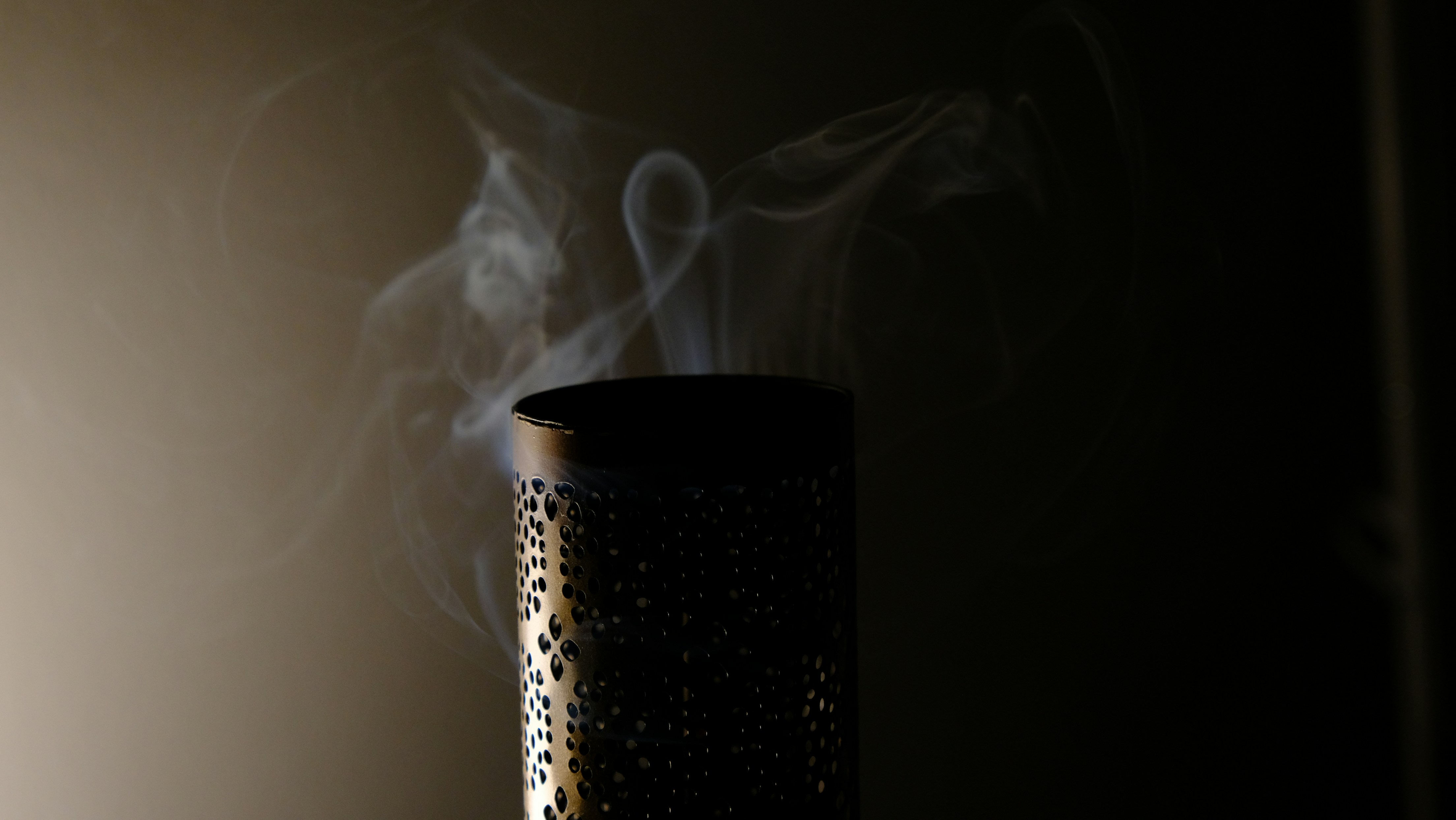 Humo saliendo de una pipa de metal oscuro.