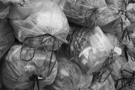 A pile of clear plastic trash bags filled with items.