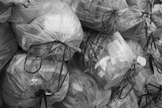 A pile of clear plastic trash bags filled with items.