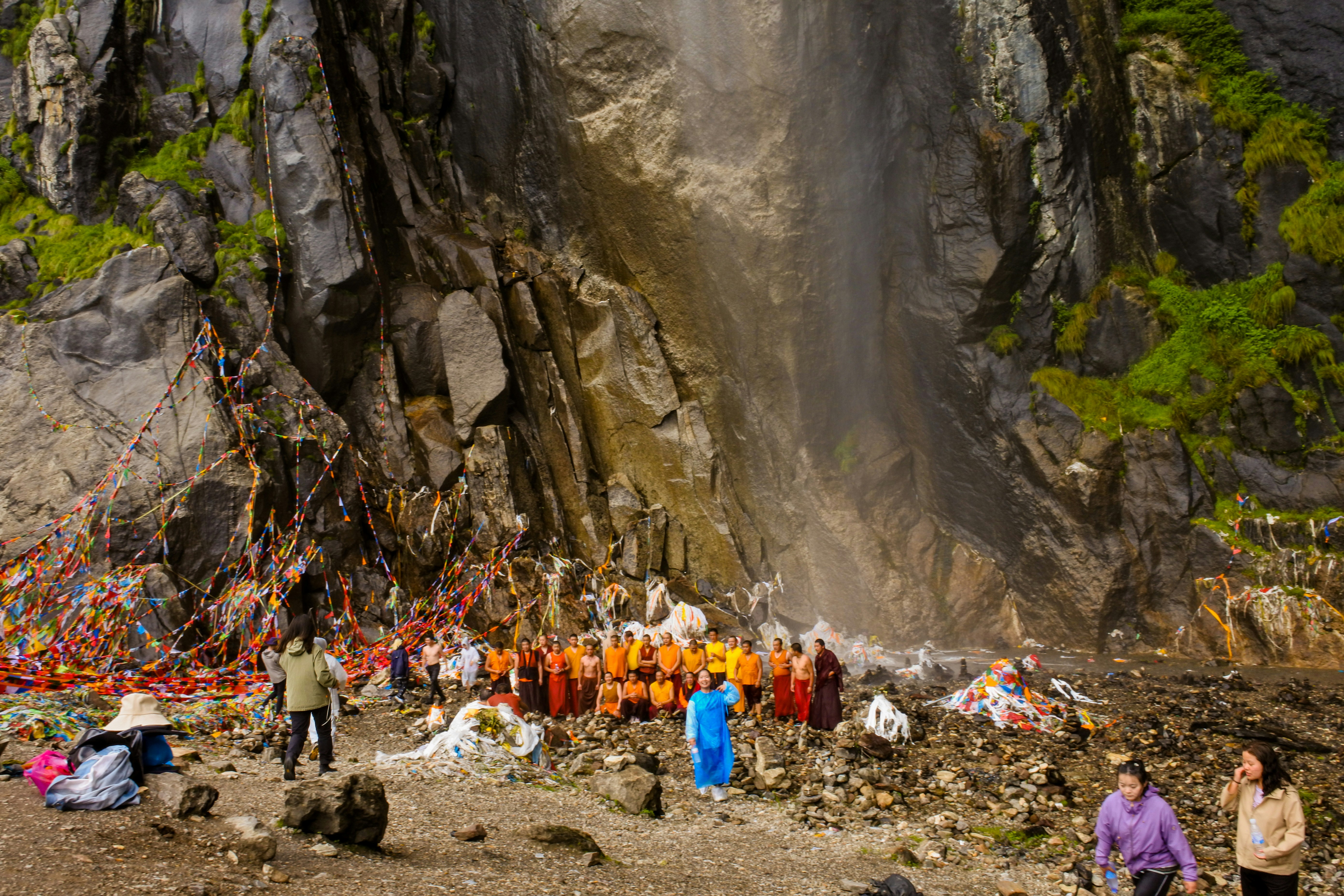 Group of people gathered at the base of a waterfall