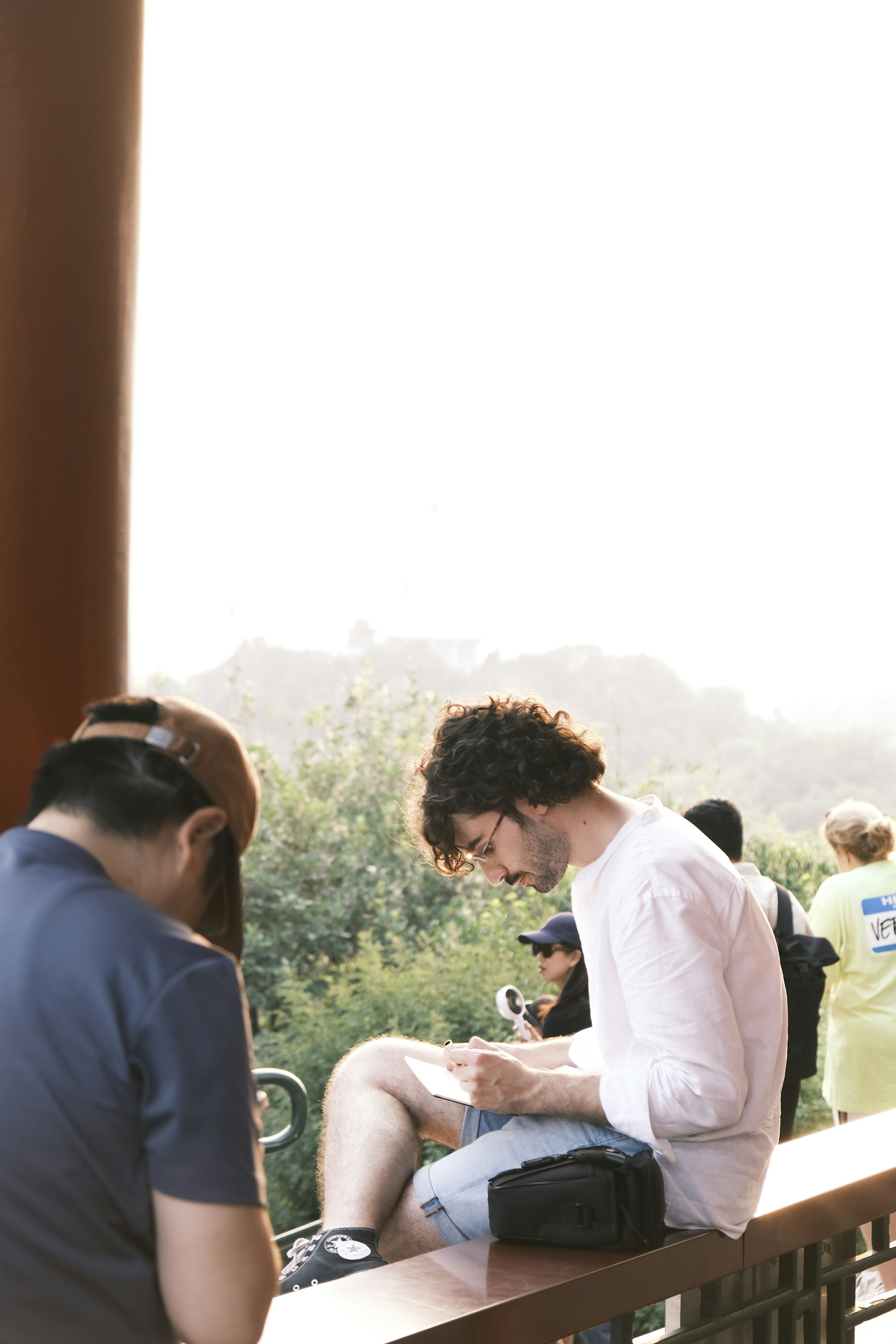 Hombre con cabello rizado sentado y leyendo