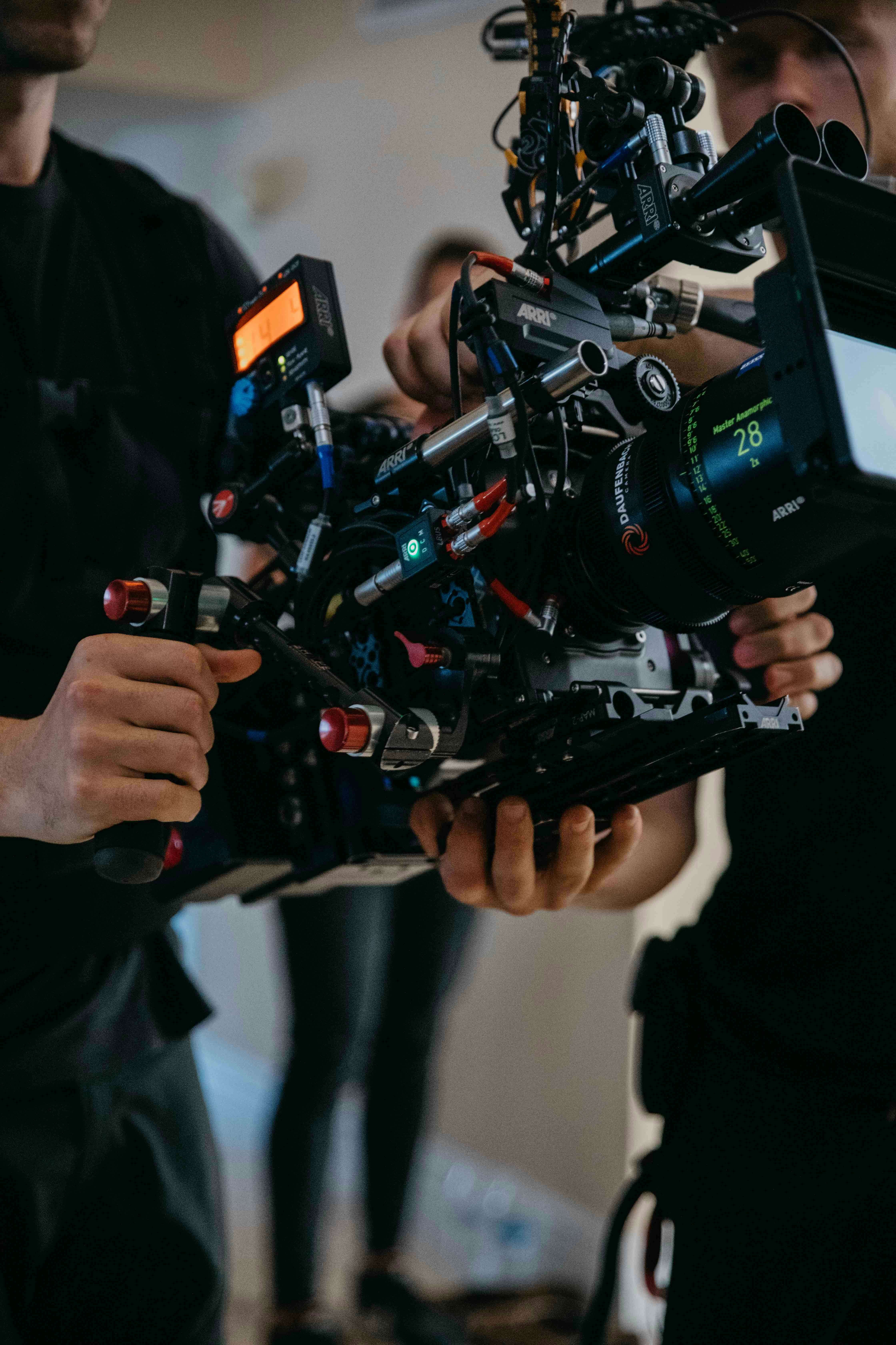 Two people holding a professional cinema camera rig.