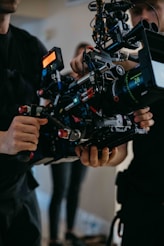 Two people holding a professional cinema camera rig.