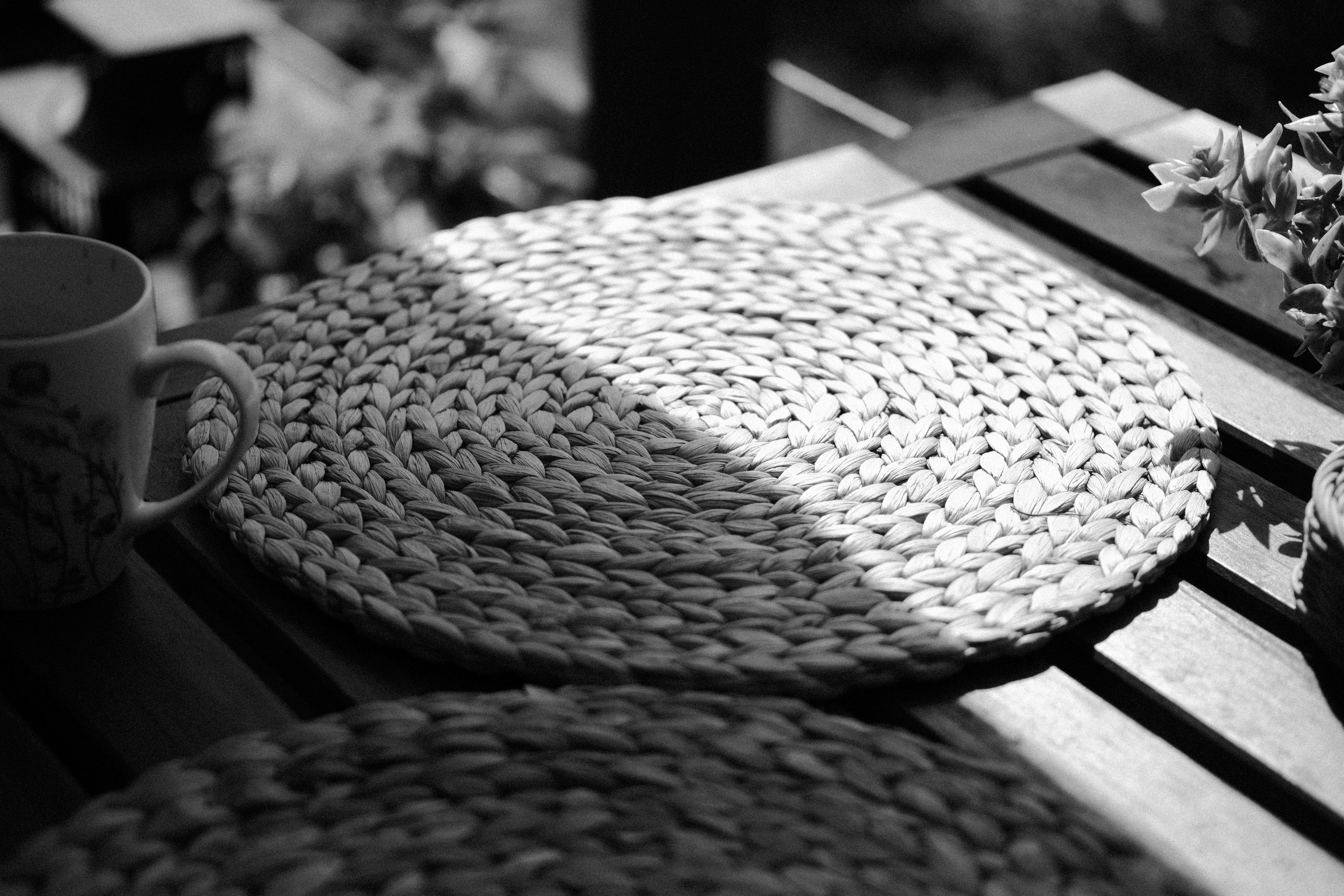 Tovaglietta tessuta su un tavolo di legno con luce solare.