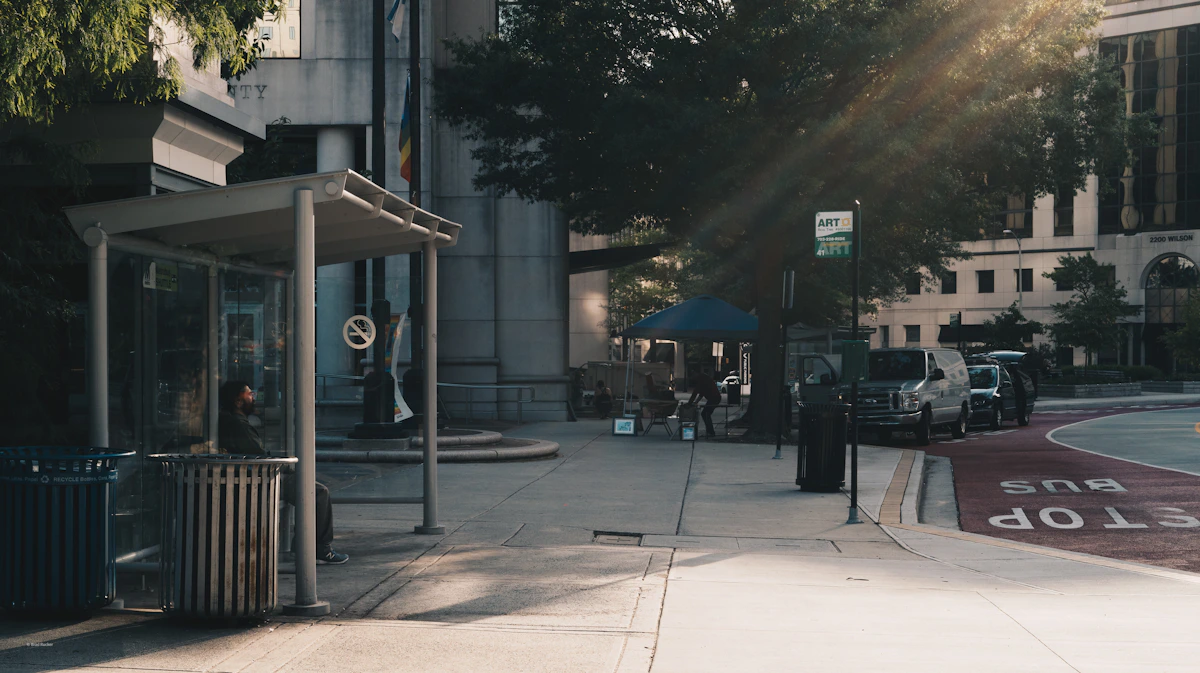 A person waiting at a city bus shelter