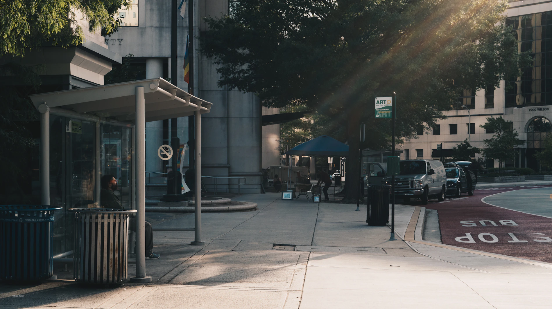 Person waiting and observing from a city bus shelter